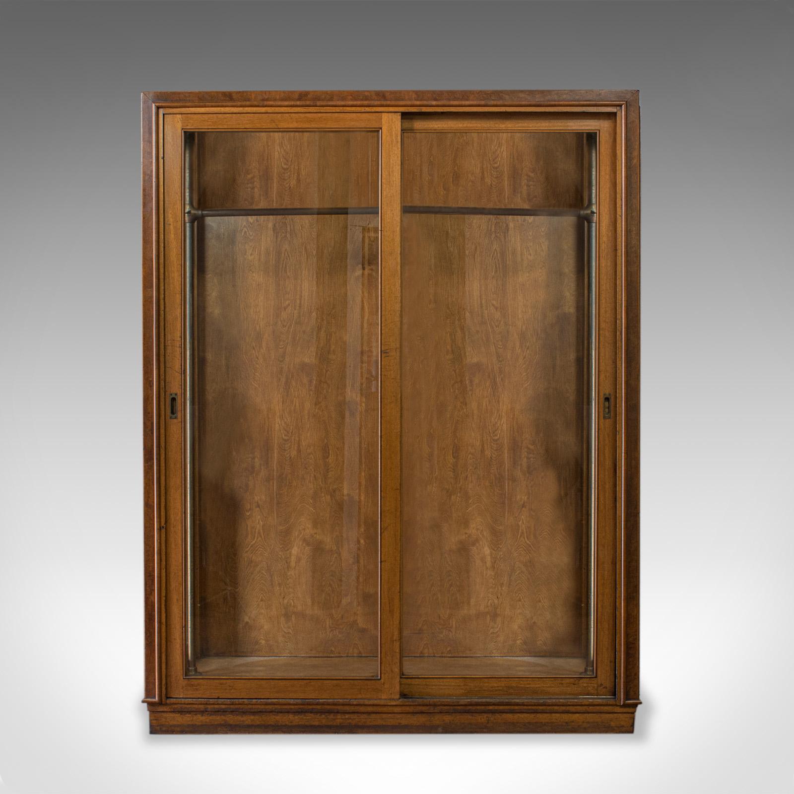 This is a substantial antique glazed wardrobe cabinet. An English, oak retail, display shop fitting cabinet by aircraft and store planning specialists George Parnall and Co, and dating to the late 19th century, circa 1900.

Select oak and burr