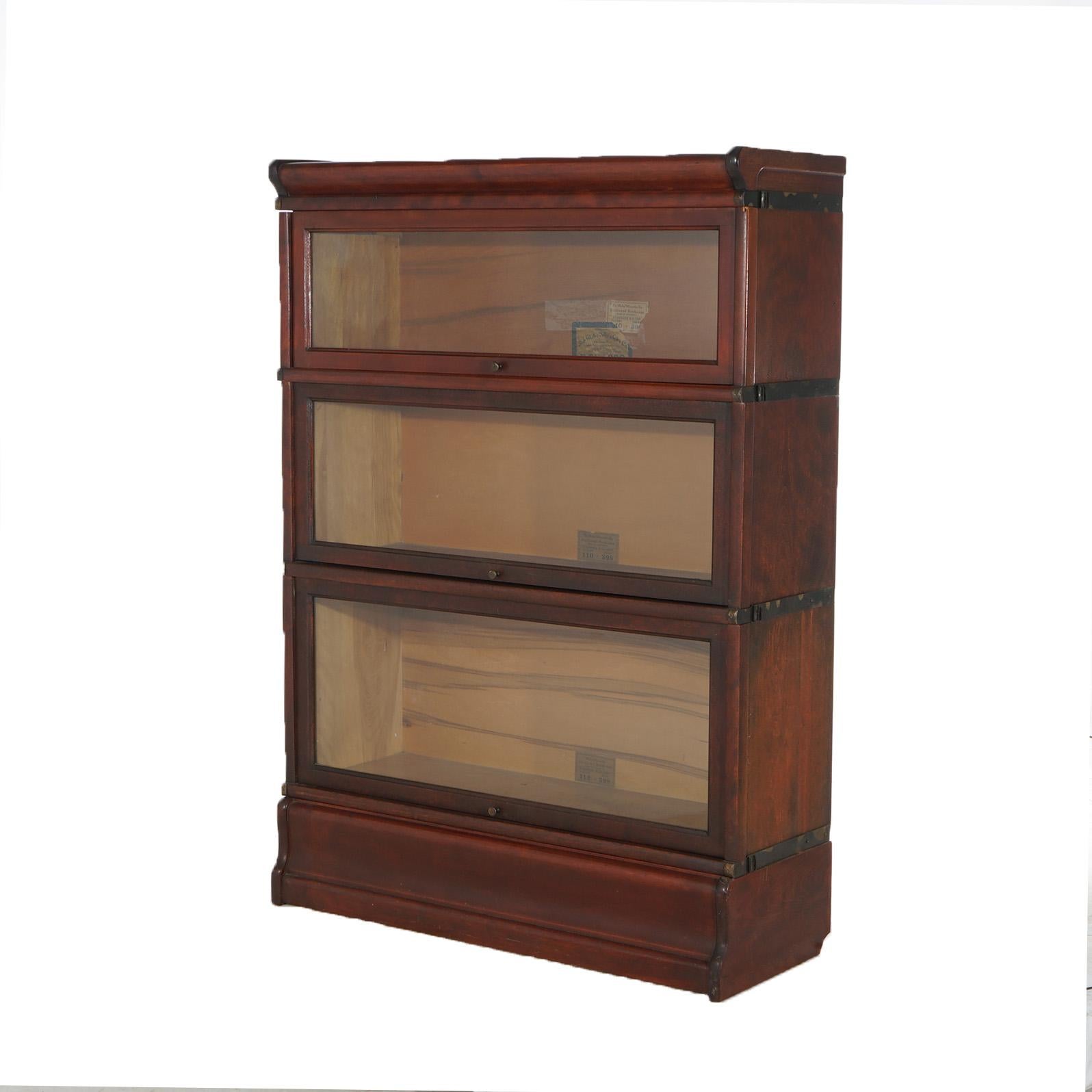 An antique Arts & Crafts barrister bookcase by Globe Wernicke offers mahogany construction with three stacks, each having pull-out glass doors and seated on ogee base, maker label as photographed, c1920

Measures - 47.5