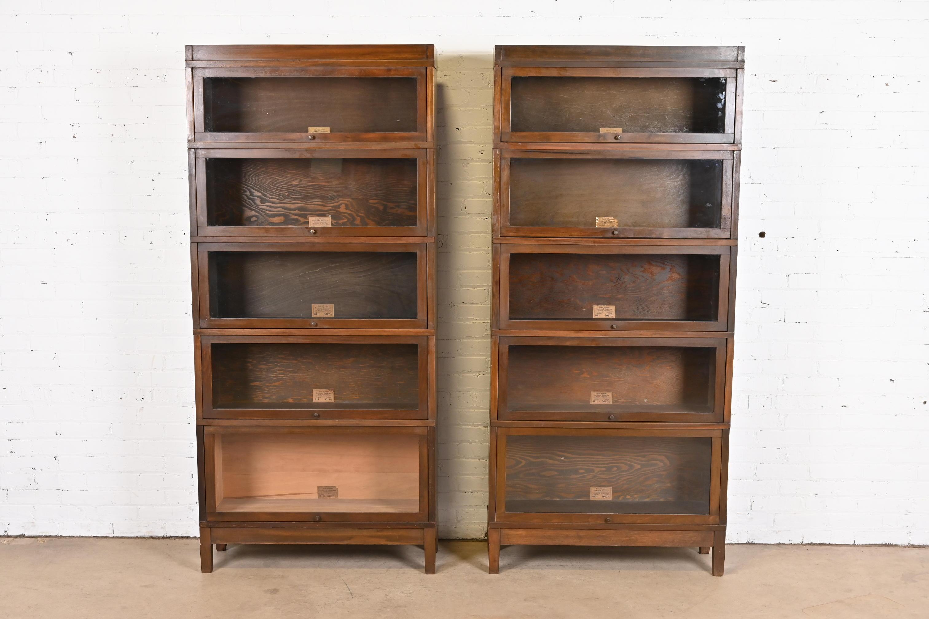 A gorgeous pair of antique Arts & Crafts five-stack barrister bookcases

By Globe Wernicke

USA, Late 19th Century

Walnut, with glass front doors and brass hardware.

Measures: 34.25