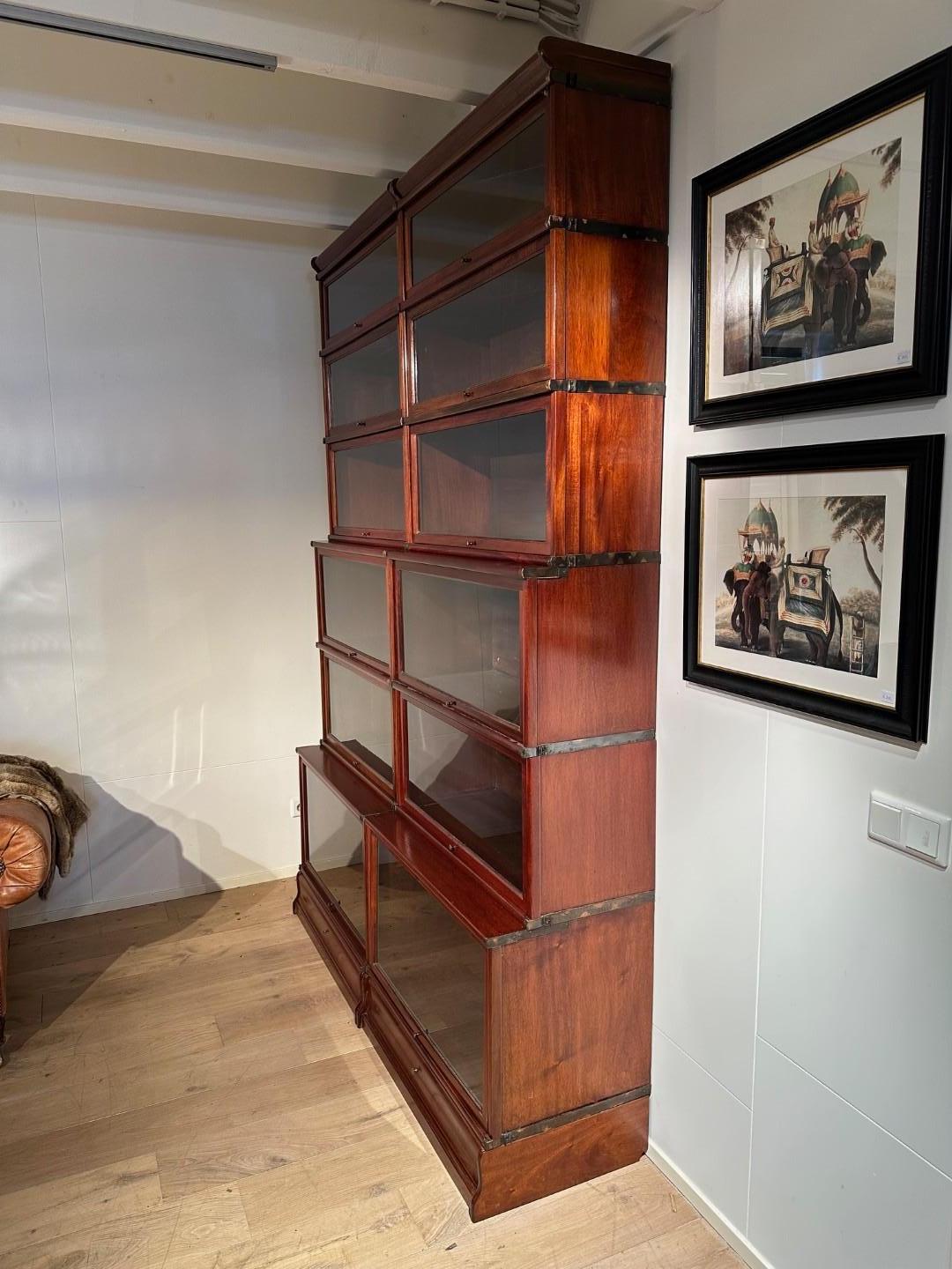 Bellissima libreria antica in mogano Globe Wernicke in perfette condizioni. L'armadio è composto da 12 parti impilabili con 2 zoccoli e 2 cappe.
Gli zoccoli contengono dei cassetti. L'armadio ha 3 diverse profondità. La particolarità di questa