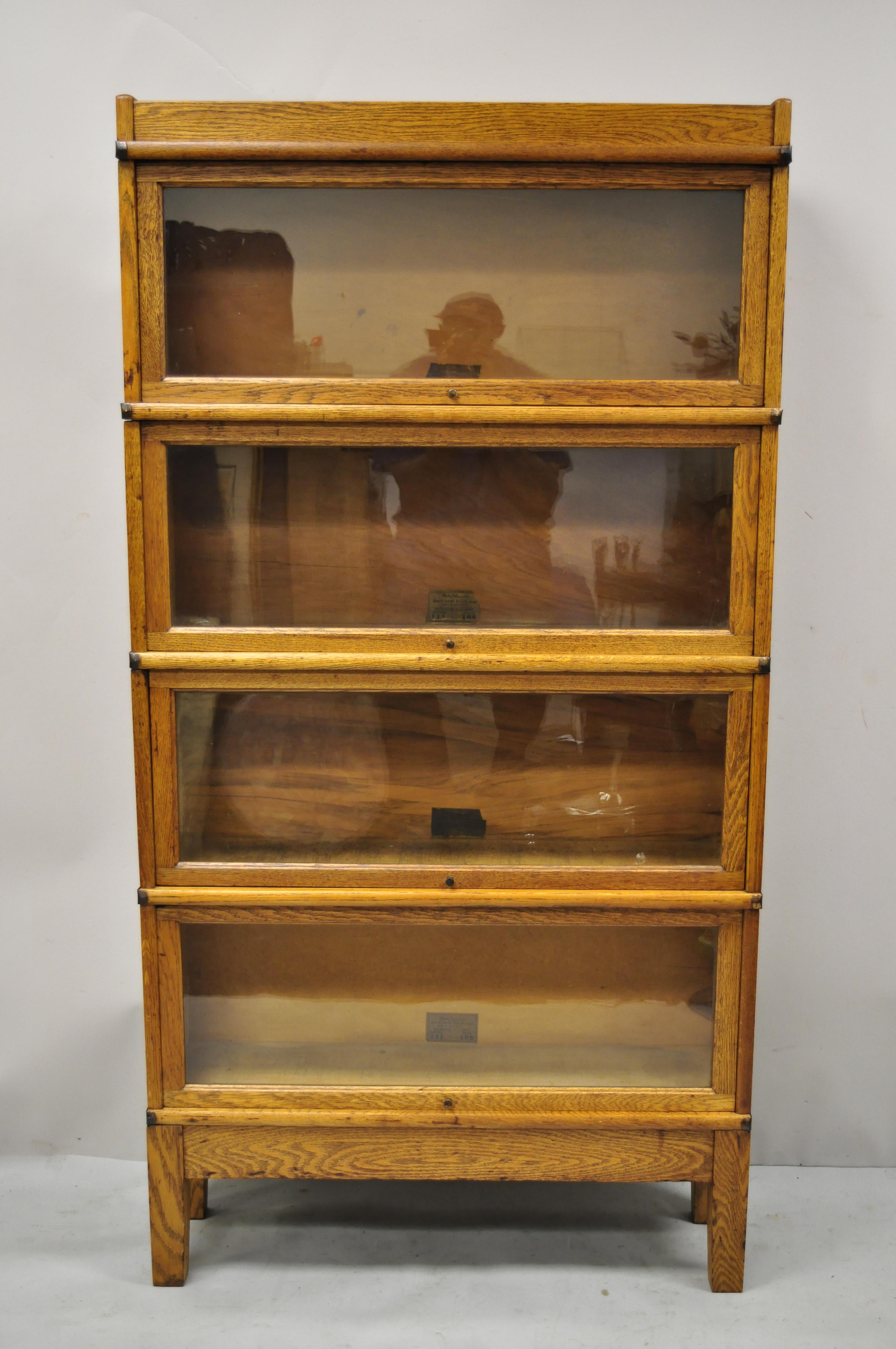 Antique Globe Wernicke golden oak 4 section stacking Barrister lawyers bookcase. Item features (4) sliding glass stacking bookcase sections, original base and top, metal side bands, original labels, very nice antique set, quality craftsmanship,