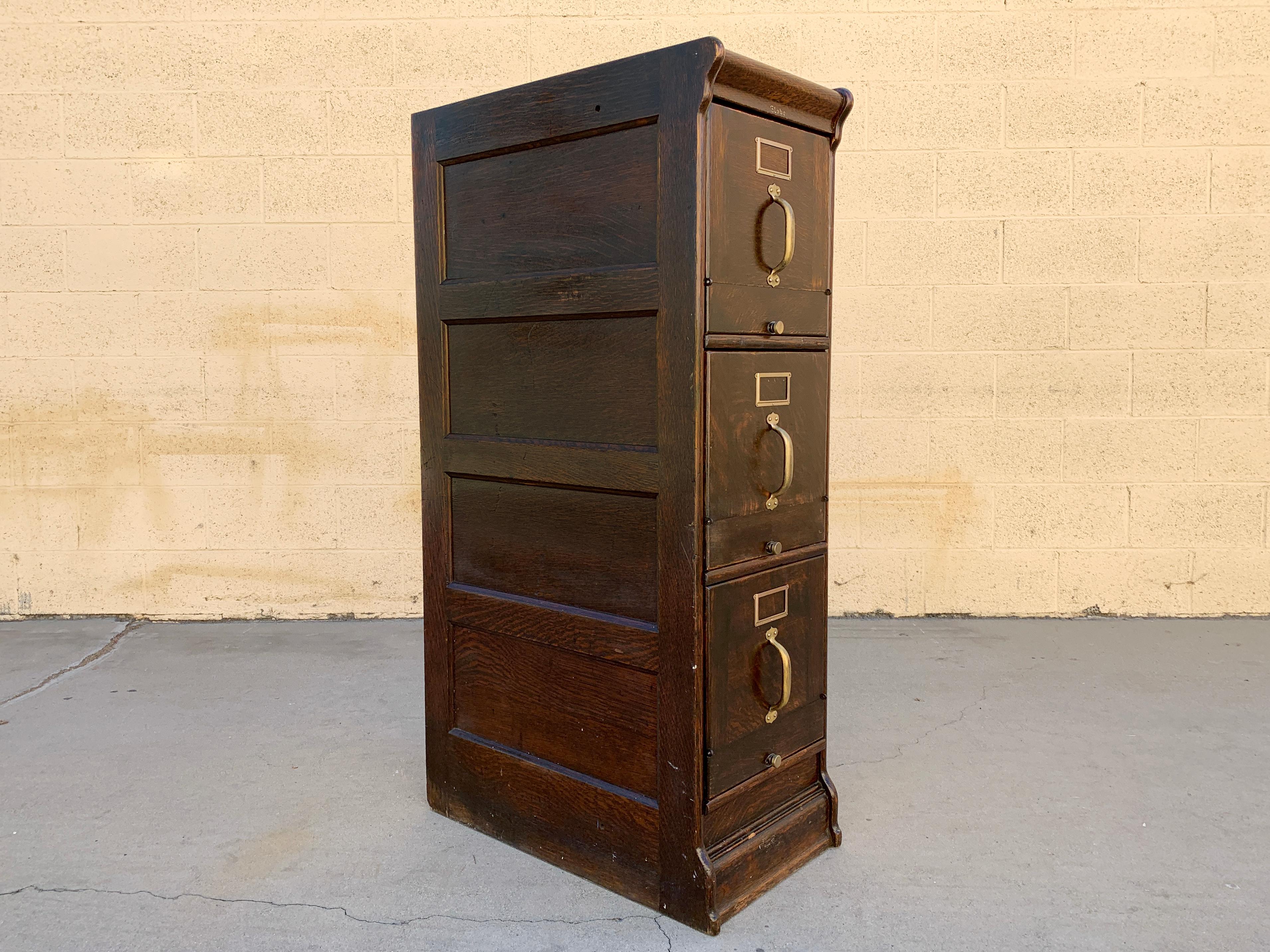 Antique American Globe Wernicke file cabinet composed of solid golden oak, circa 1900. This 3-drawer vertical unit is a beauty. Quality Globe Wernicke construction with a special design: tip out drawers. The face of each drawer can be folded open