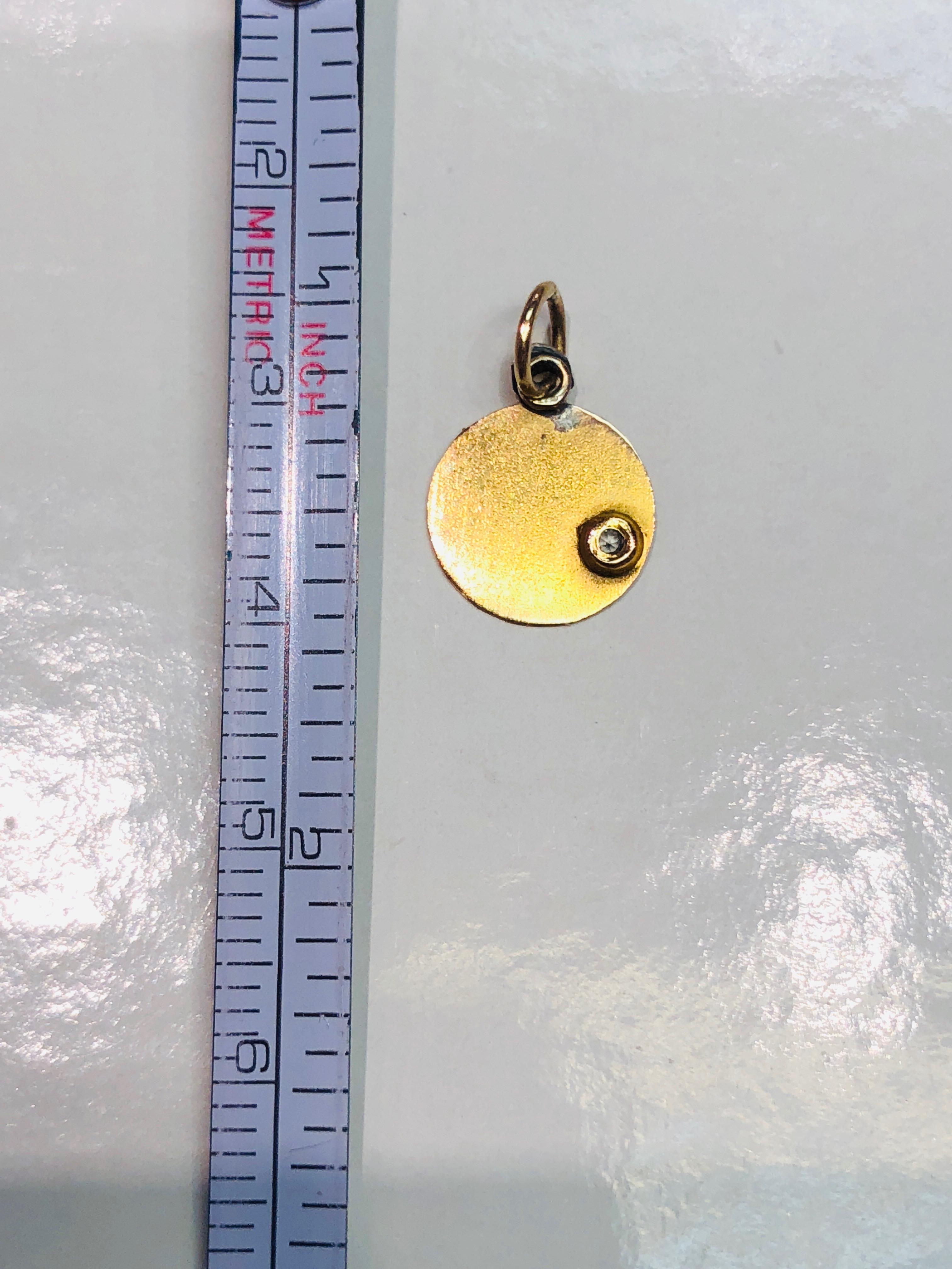 Petite round gold charm.  18K yellow gold, with black enamel lettering 