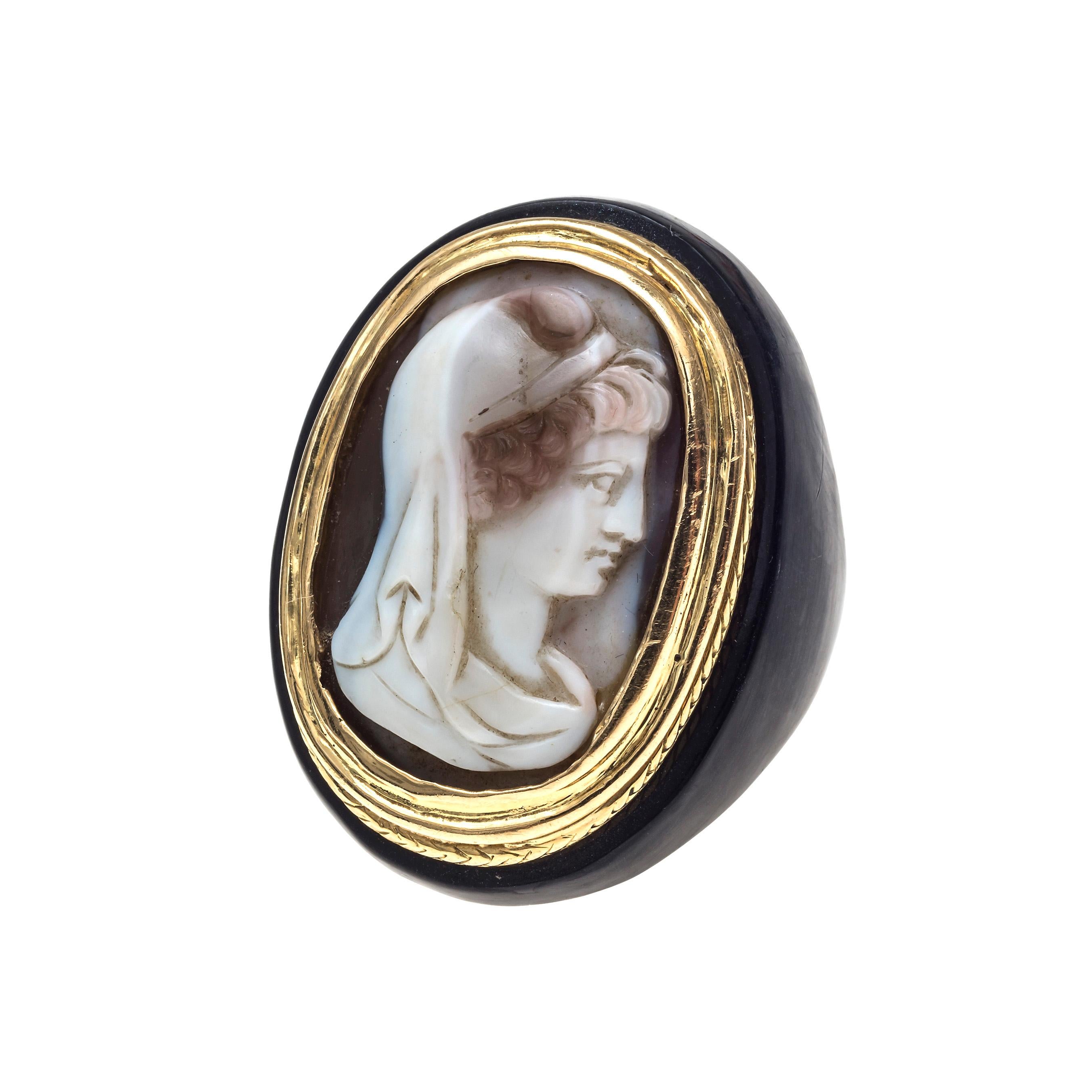 Un camée ovale sculpté en sardonyx représente un buste féminin mythologique antique de profil. Le camée a été exécuté dans la première moitié du XVIIIe siècle et monté en or 18 carats. Le bord extérieur de la monture en or a été gravé pour