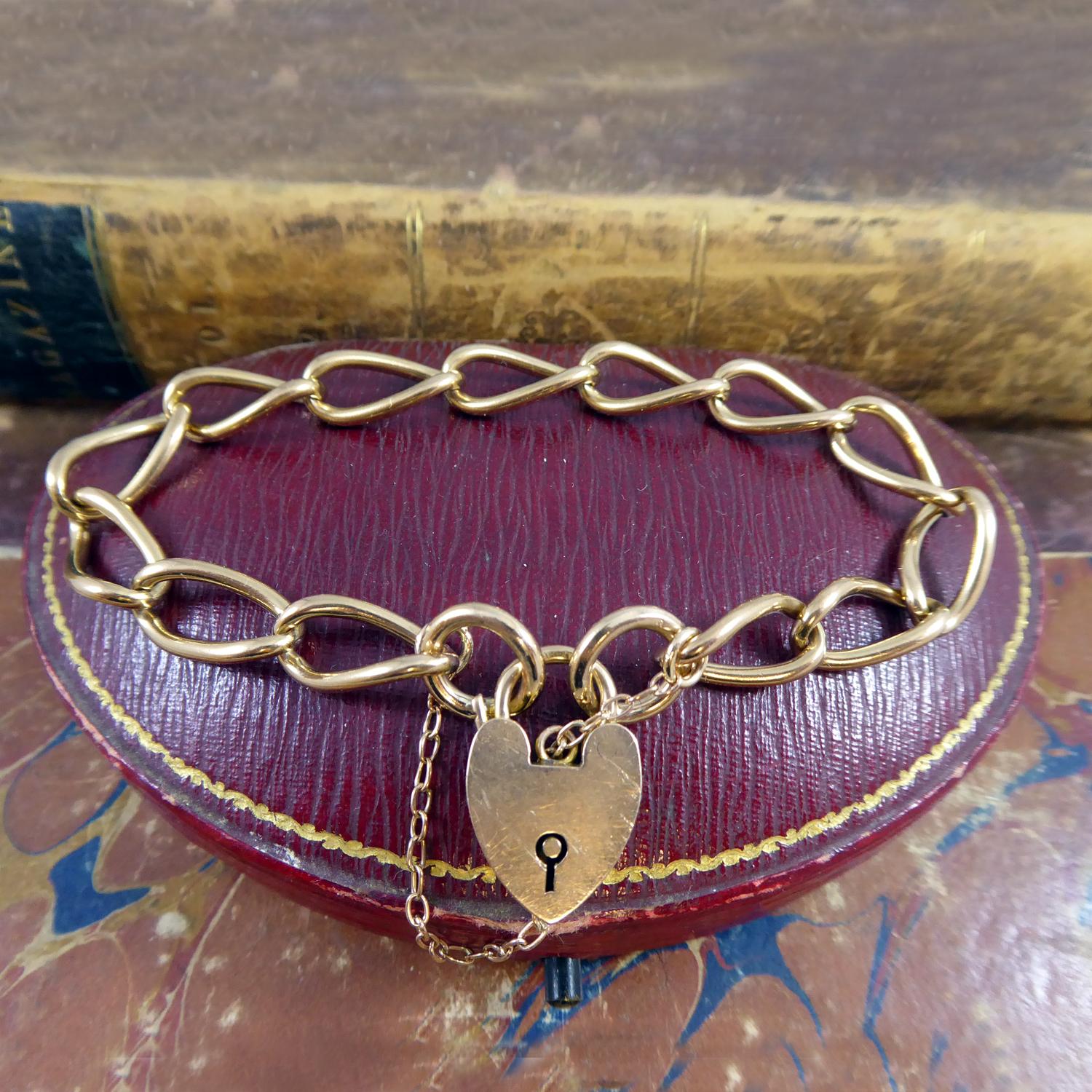 A classic style bracelet fashioned from an antique watch Albert Chain and fitted with a padlock and safety chain.  The links are solid gold of a slightly rose colour and are stamped mainly on each link 