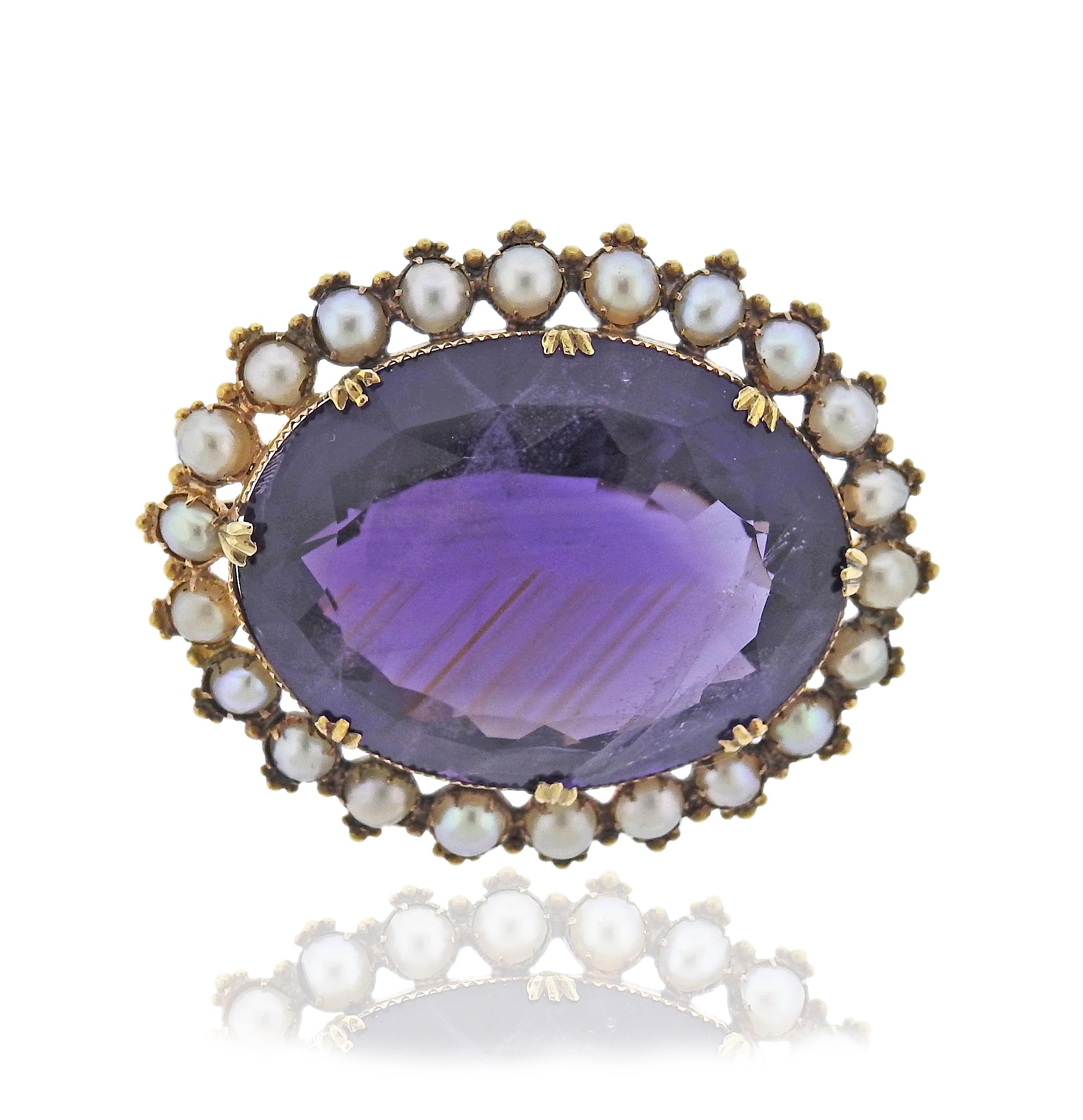 Antique 14k gold brooch, with center amethyst (with small chips present) surrounded with pearls. Brooch is 45mm x 36mm. Weight - 20 grams.