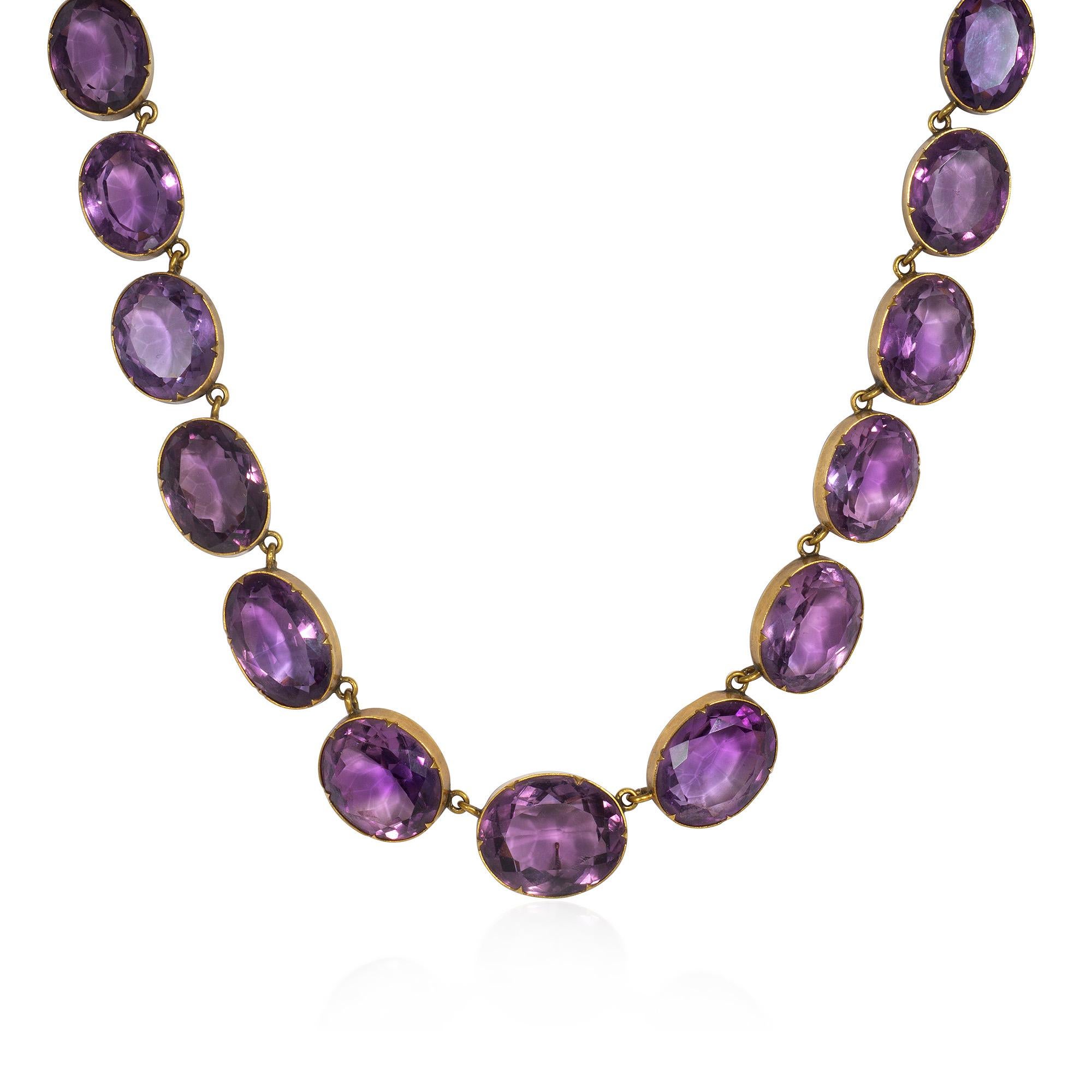 Eine antike viktorianische Gold- und Amethyst-Halskette im Rivi�ère-Stil, bestehend aus ovalen Amethysten in Lünettenfassung, die einen abnehmbaren, übergroßen, länglichen Anhänger tragen, in 15k.  England.  Begleitet von der