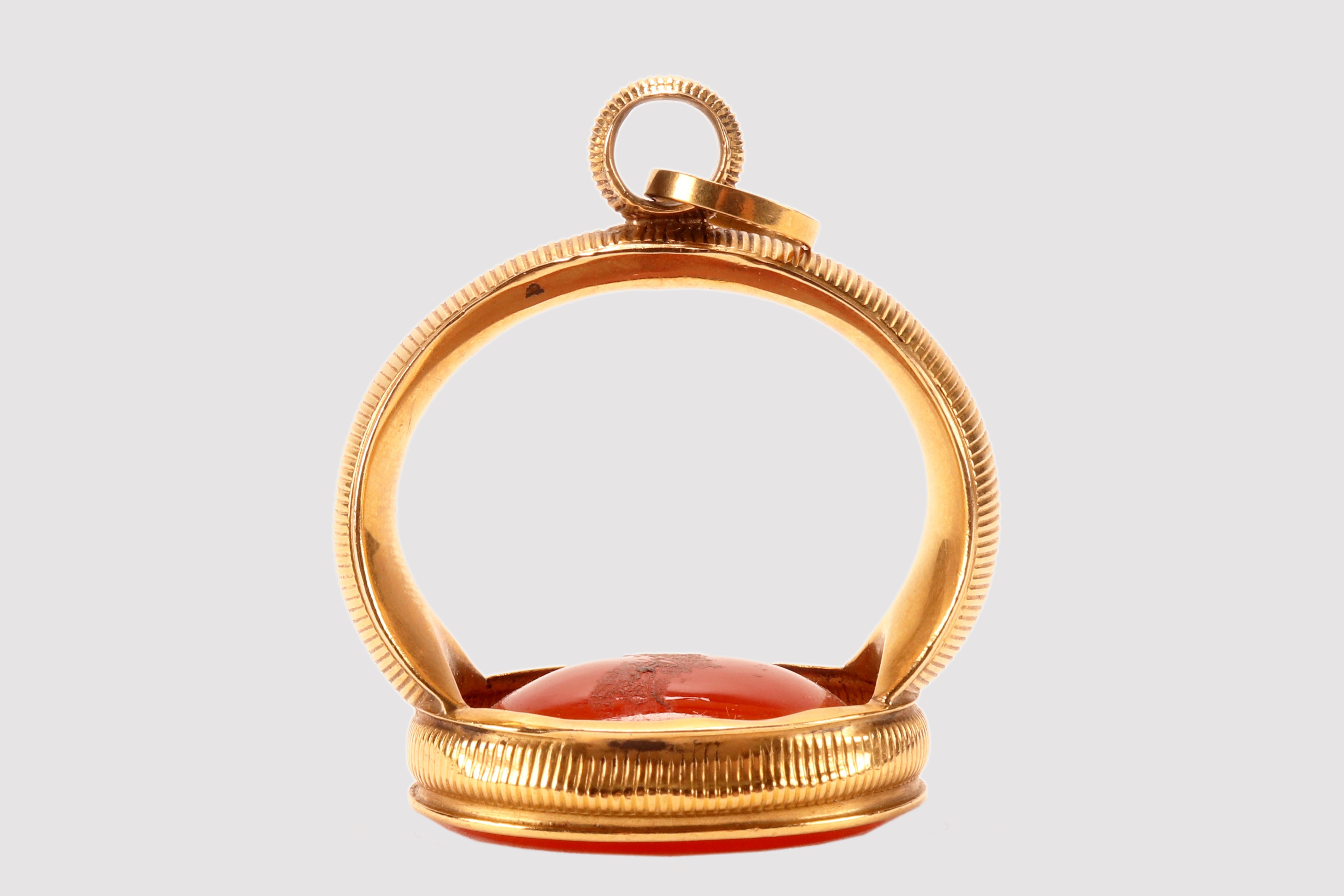 Antique 18 Kt. gold and carnelian chain seal. The matrix is never engraved carnelian, oval in shape with beveled edges. The back of the carnelian appears convex. A flat gold band embraces the carnelian edge rising like a band geometrically decorated