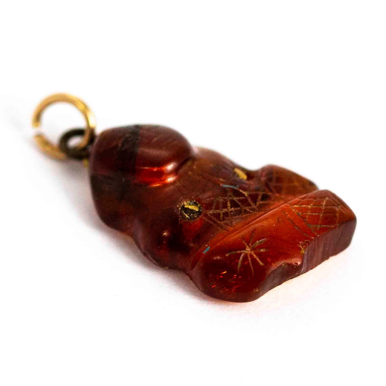 A superb antique amber pendant exquisitely carved in the form of a meditating buddha. Backed with 9 carat yellow gold.

Dimensions: 20mm x 12mm