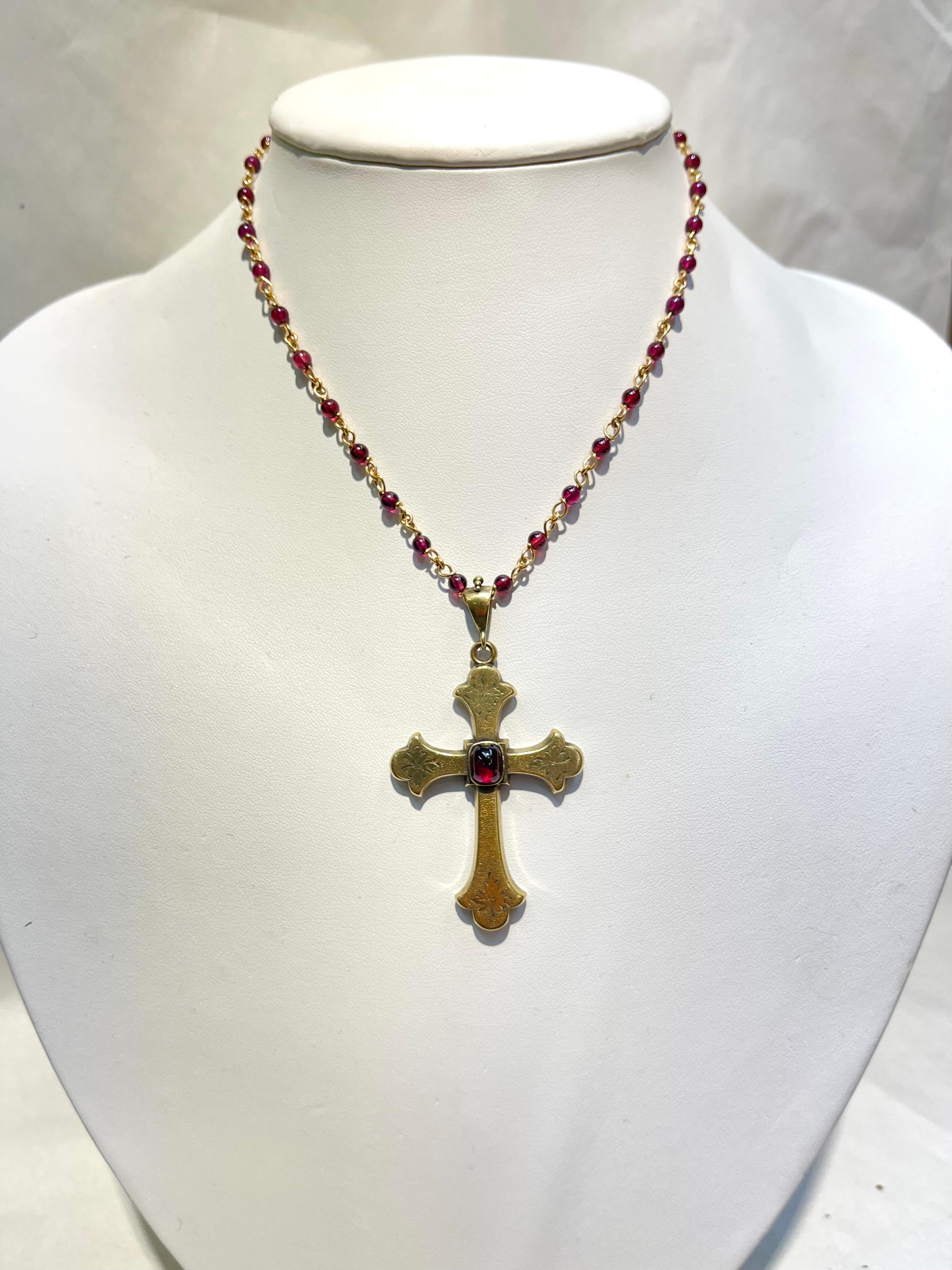 Antique Gold and Garnet Vintage Statement Cross Pendant and Necklace Simply Beautiful! The Cross centering a Cabochon Garnet is Hand crafted in 14 Karat Gold with engraved designs. Suspended from a 15.75” long Gold and Garnet Necklace. Approx. size