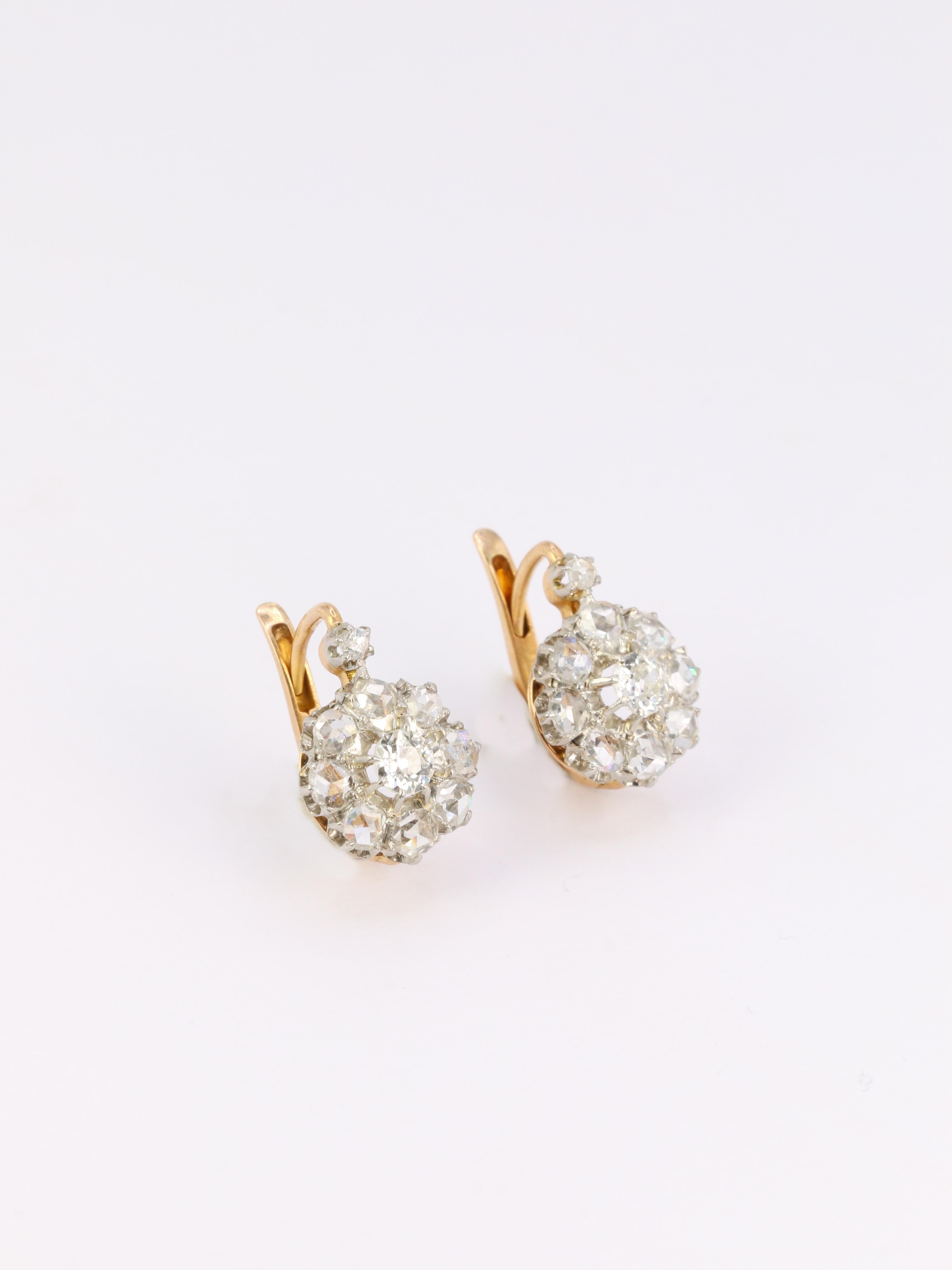 18Kt (750°/°°) yellow gold and silver sleeper earrings composed of a main round element set with a center-cut 