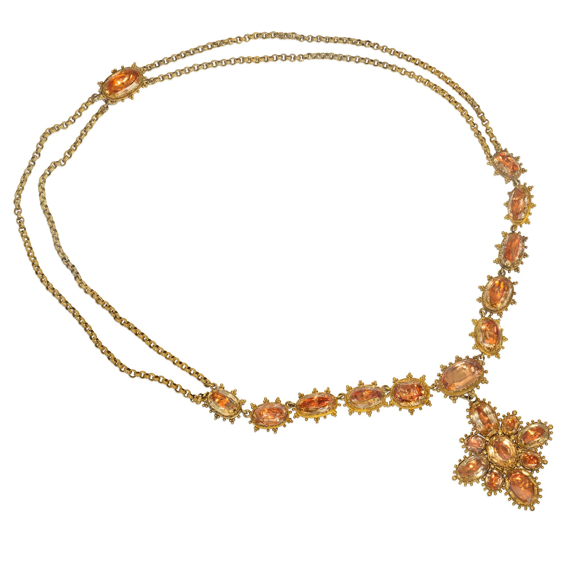 An antique Georgian period gold and topaz demi-riviere and double chain necklace comprised of foil-backed oval-cut topaz in gold granulated settings, suspending a removable quatrefoil pendant with a brooch fitting, in 18k.

Necklace measures