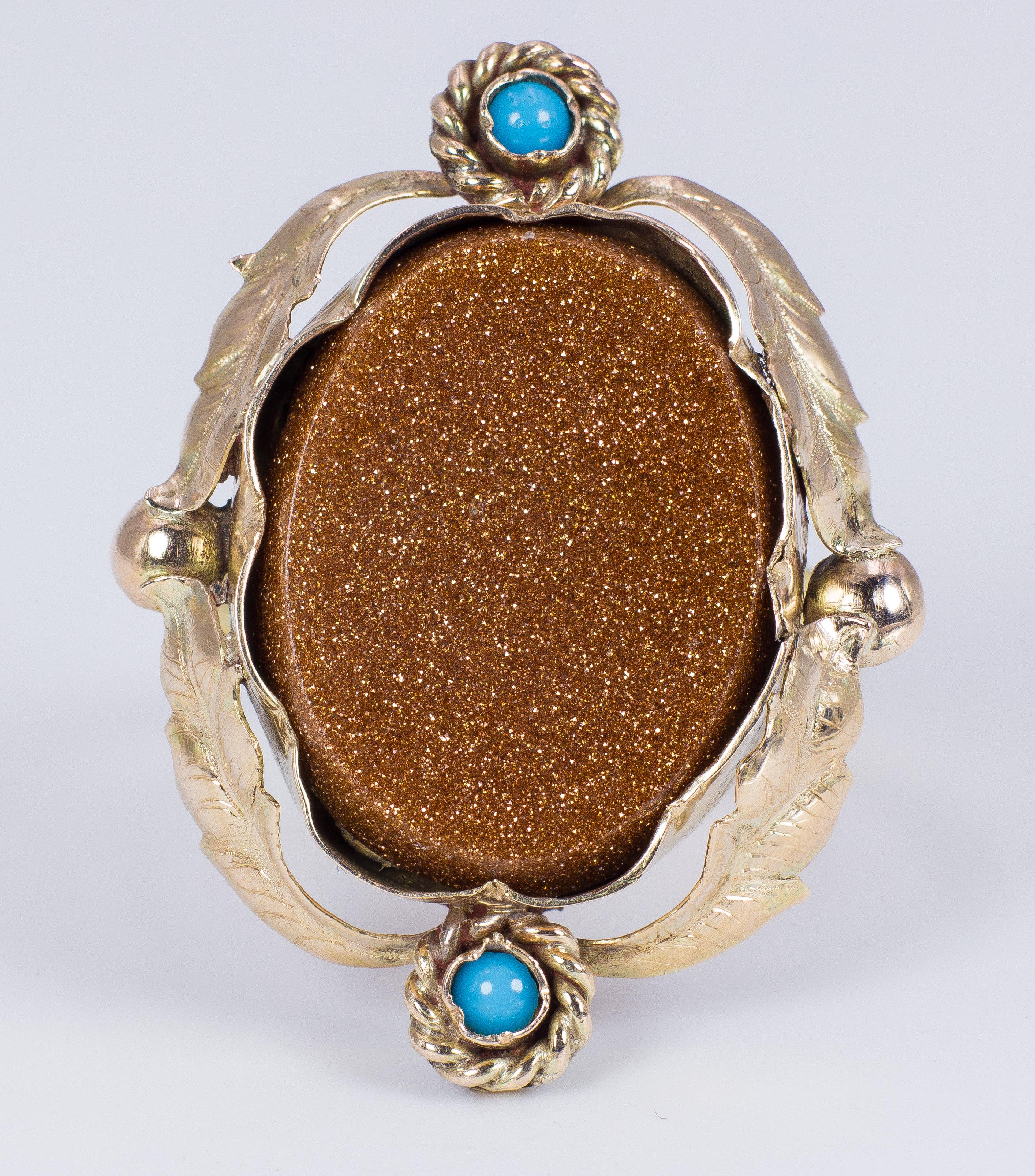This particular antique ring is a conversion ring: it borns indeed as a stickpin, that has recently converted into a ring. The head features a beautiful central orange goldstone, sets in a low-karat gold mount, with floral decorations; two