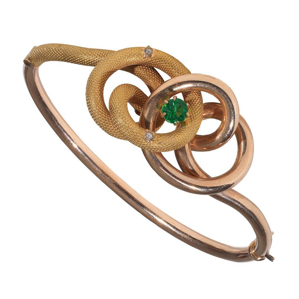 
Of central entwined shape, centered by a green tourmaline and accented by two small pearls. mounted in plain rose gold and snakeskin yellow gold.

The bangle is hinged and opens. 

Inner diameter: 55 mm

Italy, circa 1860