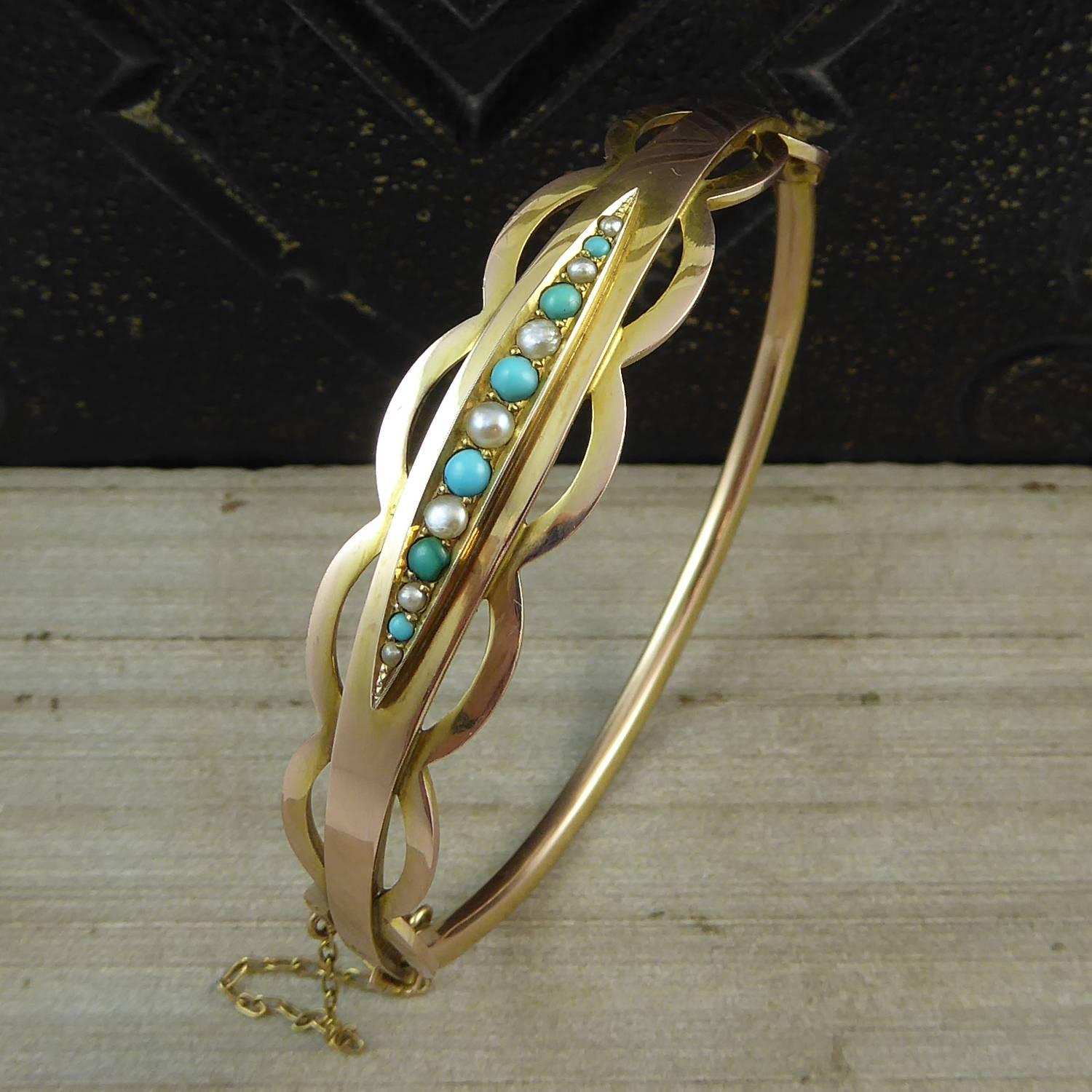 An antique bracelet dating from the English Edwardian era.  Set to the front half with a row of turquoise and pearls, graduating down in size from the central pearl, in a navette shaped mount to a plain polished yellow gold band.  The edges of the
