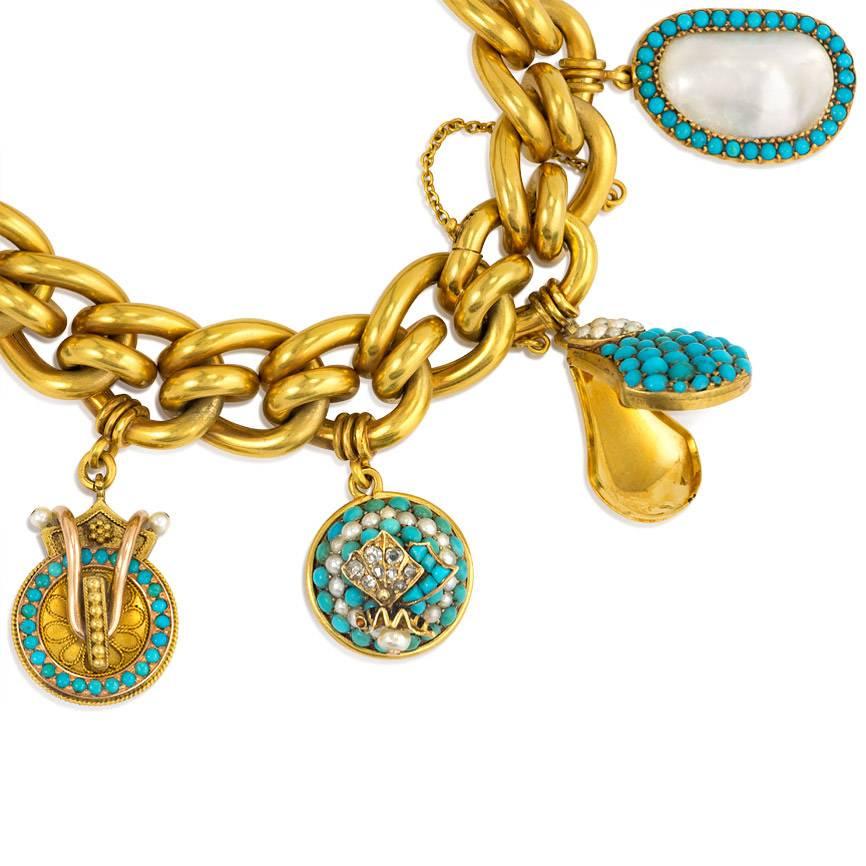 An antique gold fancy link bracelet suspending nine assorted gold, turquoise, and pearl charms in 18k, including two serpents, a butterfly, a diamond-winged insect, a handbag locket, and a rock crystal bead overlaid with gold, turquoise and seed