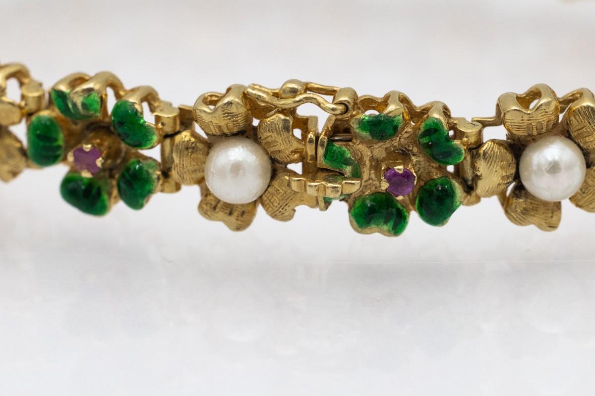 Old gold bracelet in the shape of small flowers joined together, decorated with green enamel, pearls and pink sapphires.

Origin: Western Europe, 2nd half of the 20th century.

Comfortable bracelet with a clasp with two safety eights.

Made of
