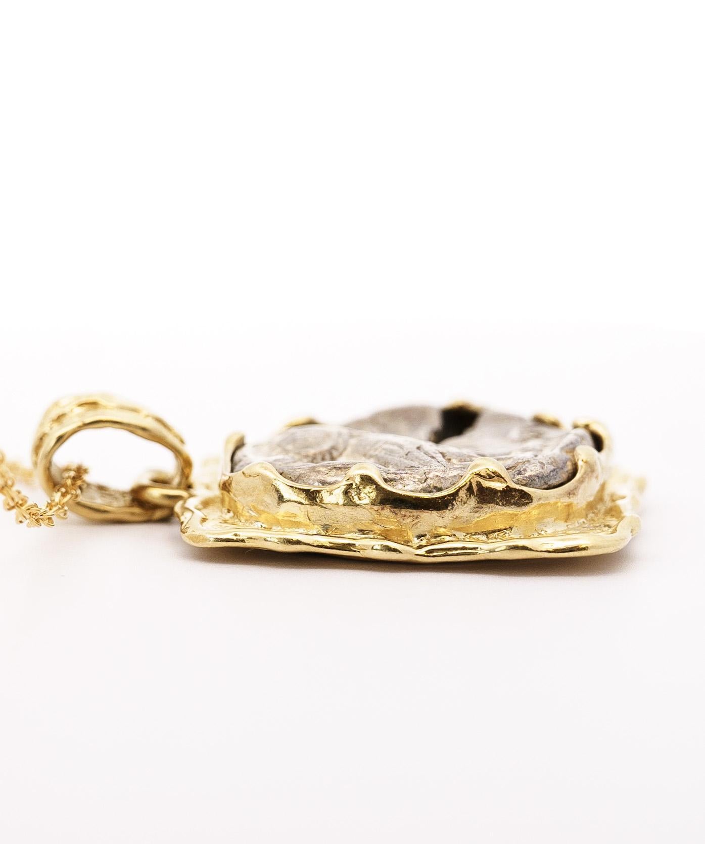 Antico ciondolo a forma di tetradramma greco del 400-413 a.C. circa, incastonato in un castone in oro giallo 14K con finitura in oro spazzolato. Misura 1,1 x 1,5 pollici e pesa 27 grammi. Questo pezzo storico è una meraviglia per gli occhi e una