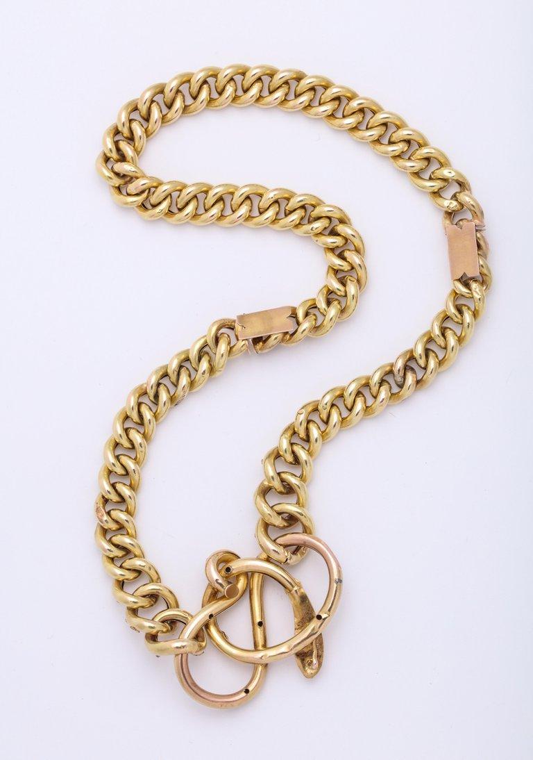 A beautiful antique 14 kt gold classic link snake necklace enhanced by a set diamond and pearl in the head.  There are two closures which enable it
to be worn as two bracelets. This is a wonderful example of a classic 
antique piece not easily found.