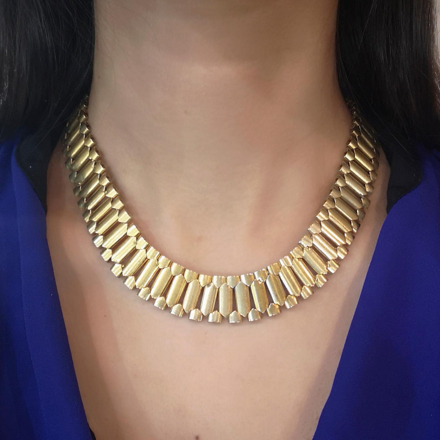 A Victorian gold collar necklace, comprising brick style bar and terminal links with a matt finish, fire gilded, patina, mounted in 15ct gold, circa 1870.
Length approximately 420mm, width approximately 18mm.