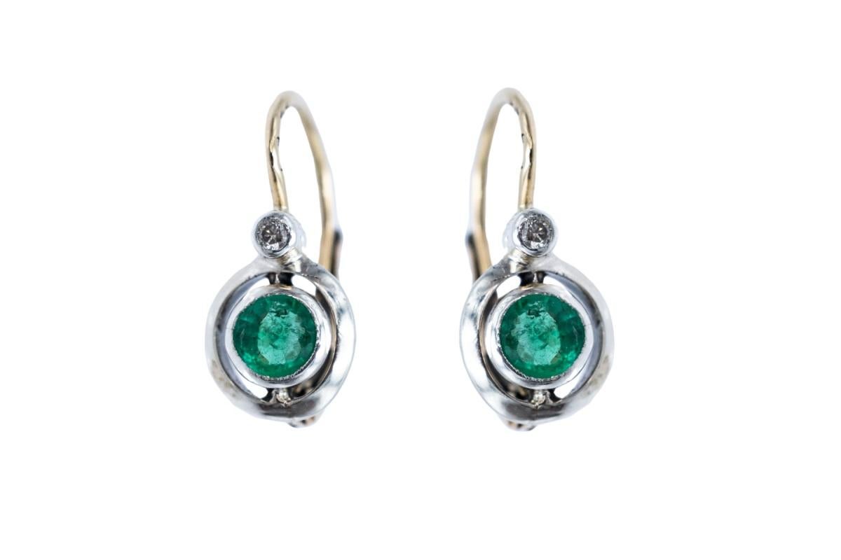 Old Art Deco earrings made of 14-carat gold with silver elements, studded with diamonds and emeralds.

Delicate earrings with diamonds with a total weight of 0.03ct and round emeralds with a total weight of 0.45. Beautiful, light green, intense