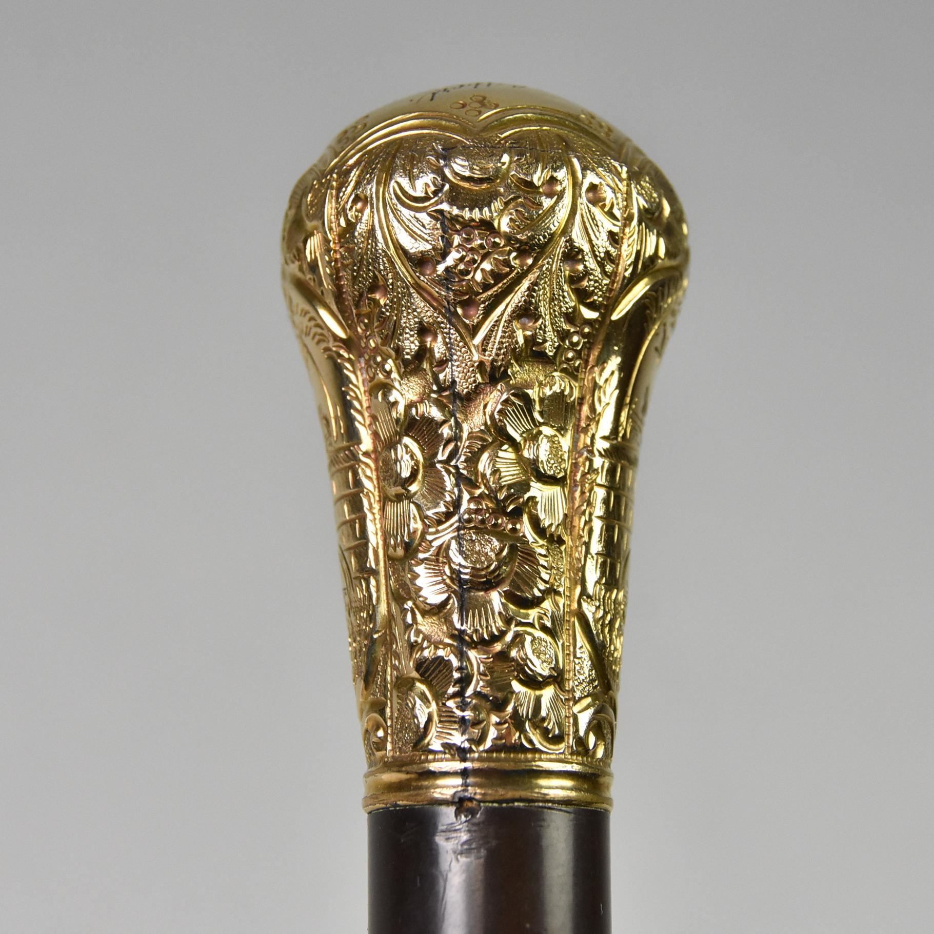 Antico bastone da passeggio di fine secolo in legno ebanizzato. La parte superiore, riempita d'oro, presenta una decorazione floreale e reca l'iscrizione William Gilbert to A.S. Cobb, Dunkirk, NY. Alcune piccole ammaccature sulla testa. Lunghezza