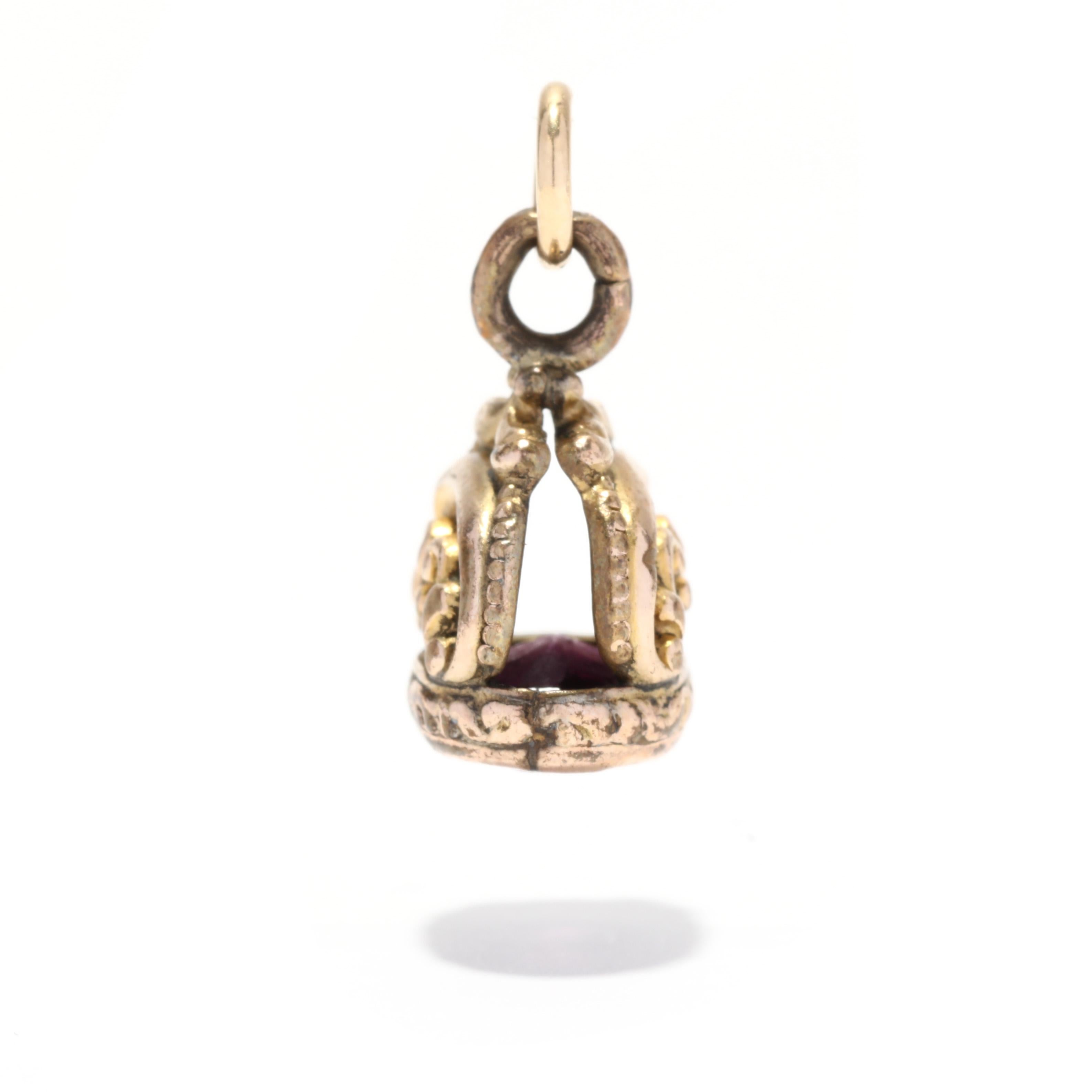 A victorian gold filled purple stone watch fob charm. This small charm features an ornately engraved scroll design with a bezel set purple stone and a thin bail. Please note that this stone has a large chip but is stable in the mounting.

Length:
