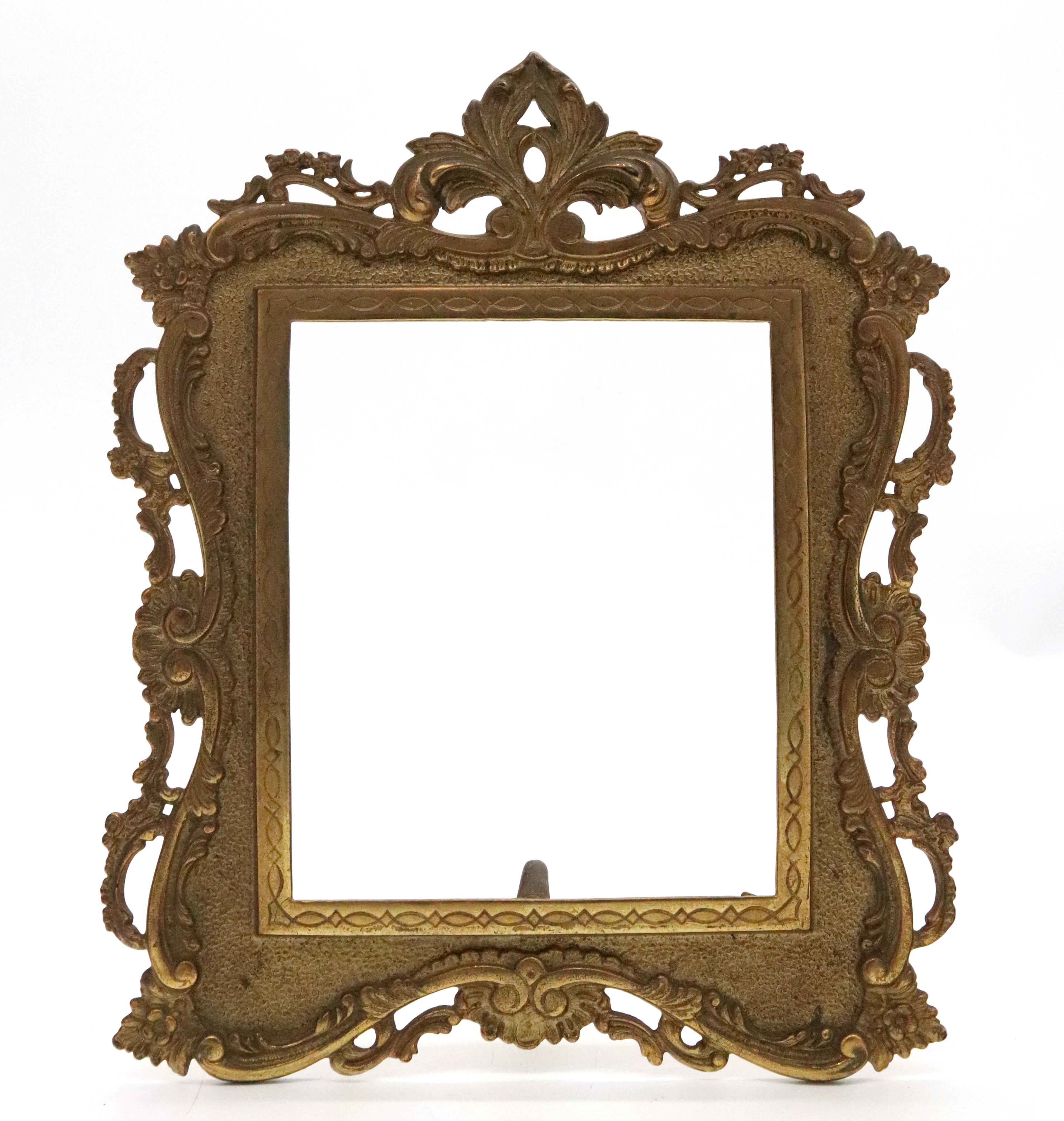 Ce cadre photo ancien est en très bon état et possède sa belle finition dorée d'origine. Le cadre est fait de fer finement moulé et est très détaillé. Il possède le bras d'origine au dos et des languettes pour maintenir un miroir ou une photo dans