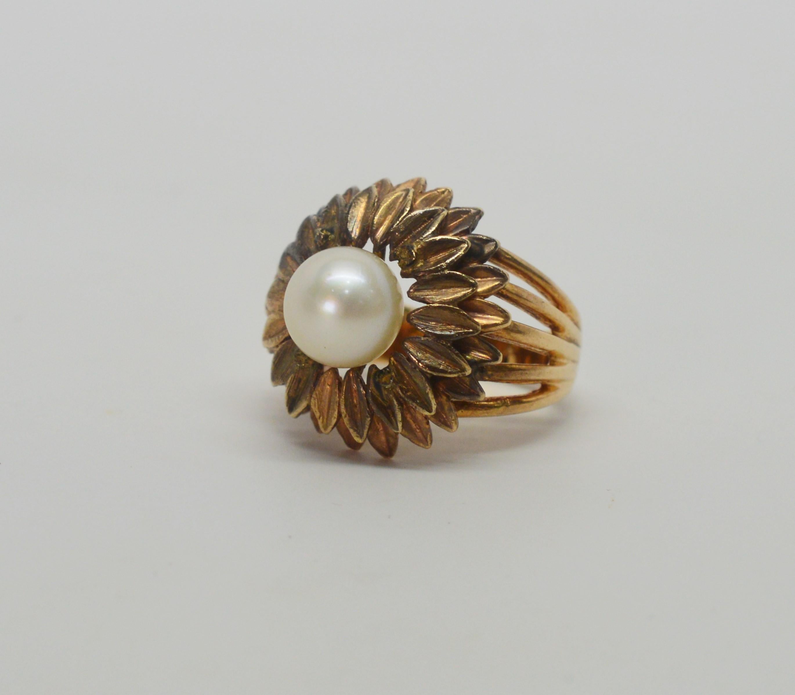 Abundant hand tooled petals in fourteen carat yellow gold with a antique gold patina finish surround the lustrous pearl center to create this pleasing floral burst antique ring.  In size six, this quality ring is crafted with a generous five prong