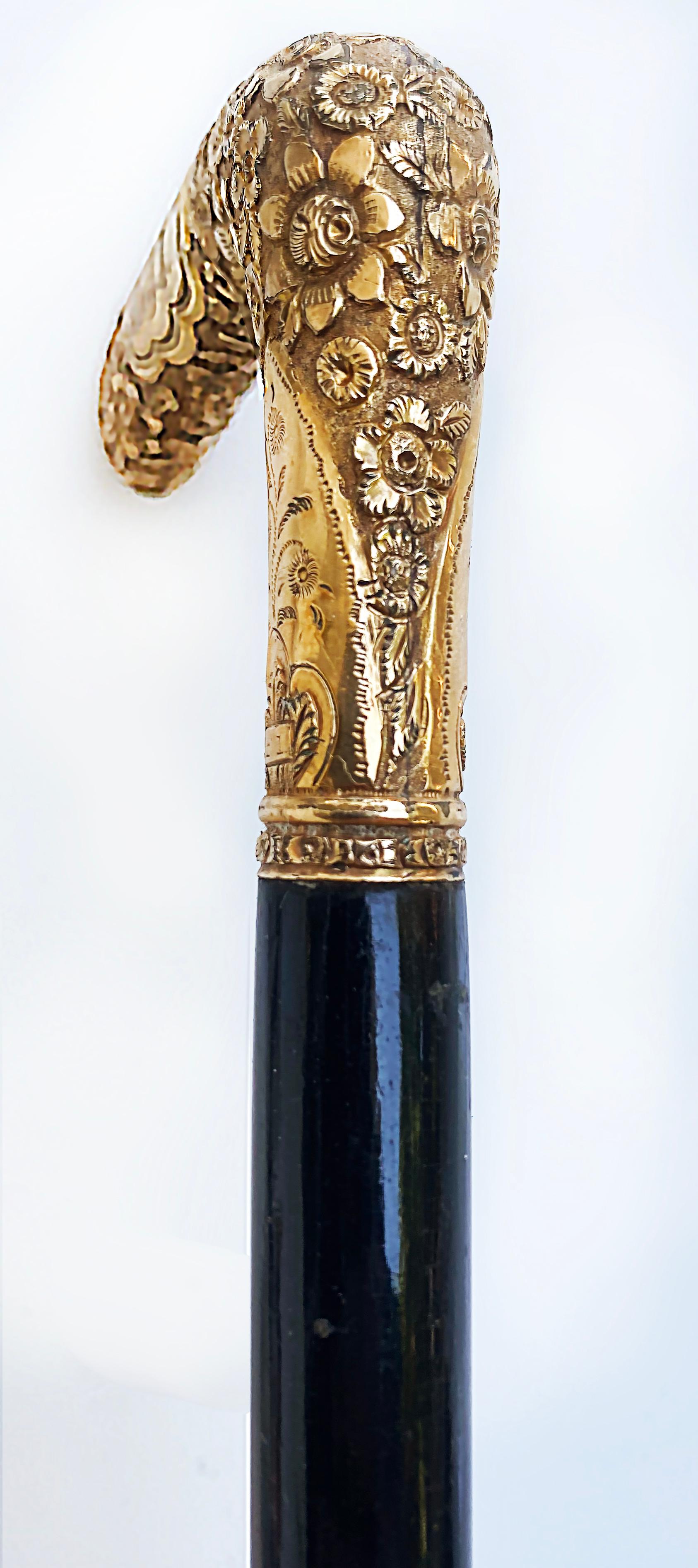 Antique Gold Floral Repousse Monogrammed Walking Stick 

Offered for sale is an antique gold-handled walking stick with a floral repousse design. The handle has an engraved monogram and is supported by an ebonized wood stick. The end has a brass