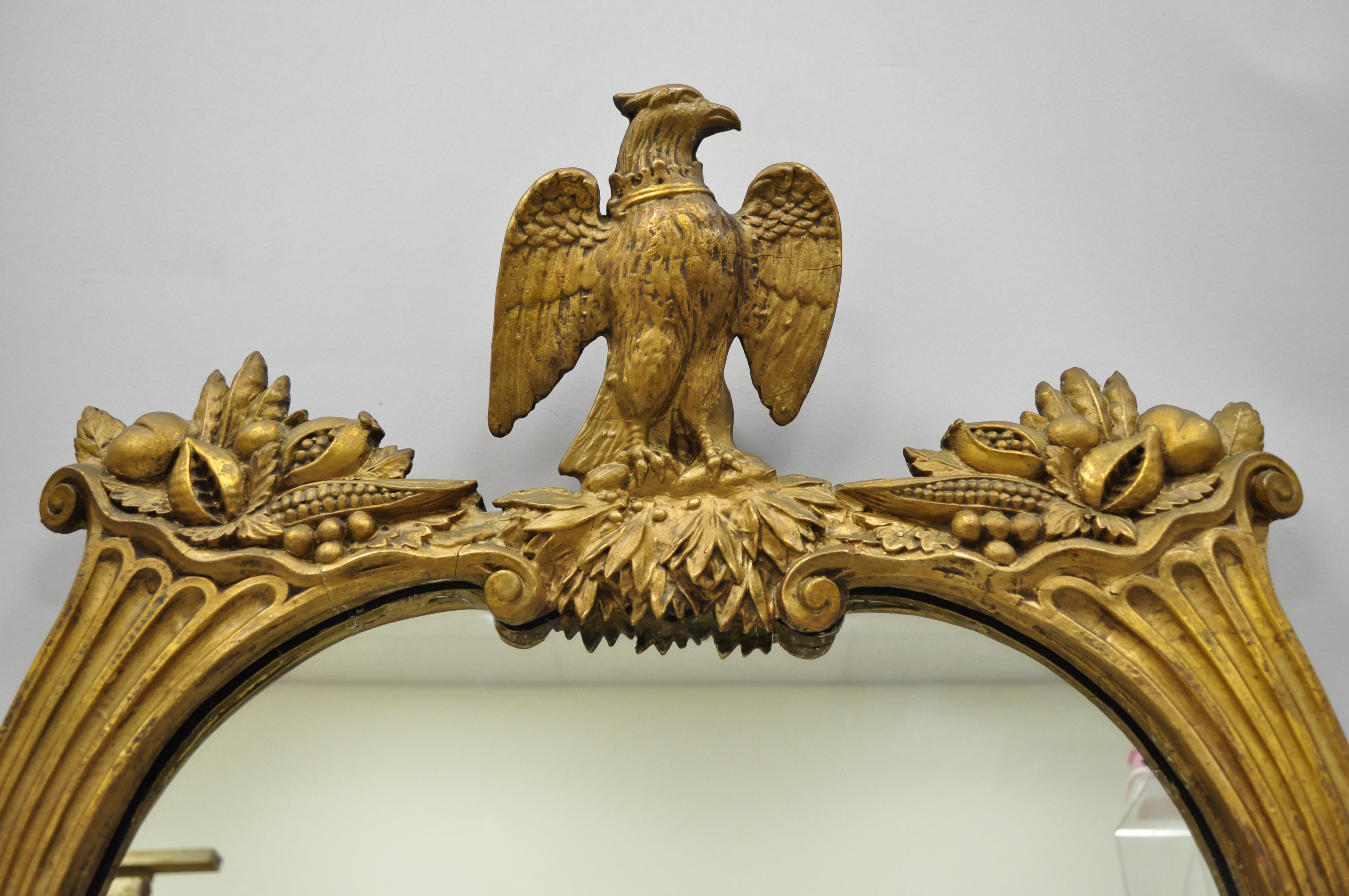 Antique gold gilt gesso federal style wall mirror with eagle and cornucopia. Item features gilt gesso eagle crest and cornucopia frame, very nice antique item, circa 1900. Measurements: 27