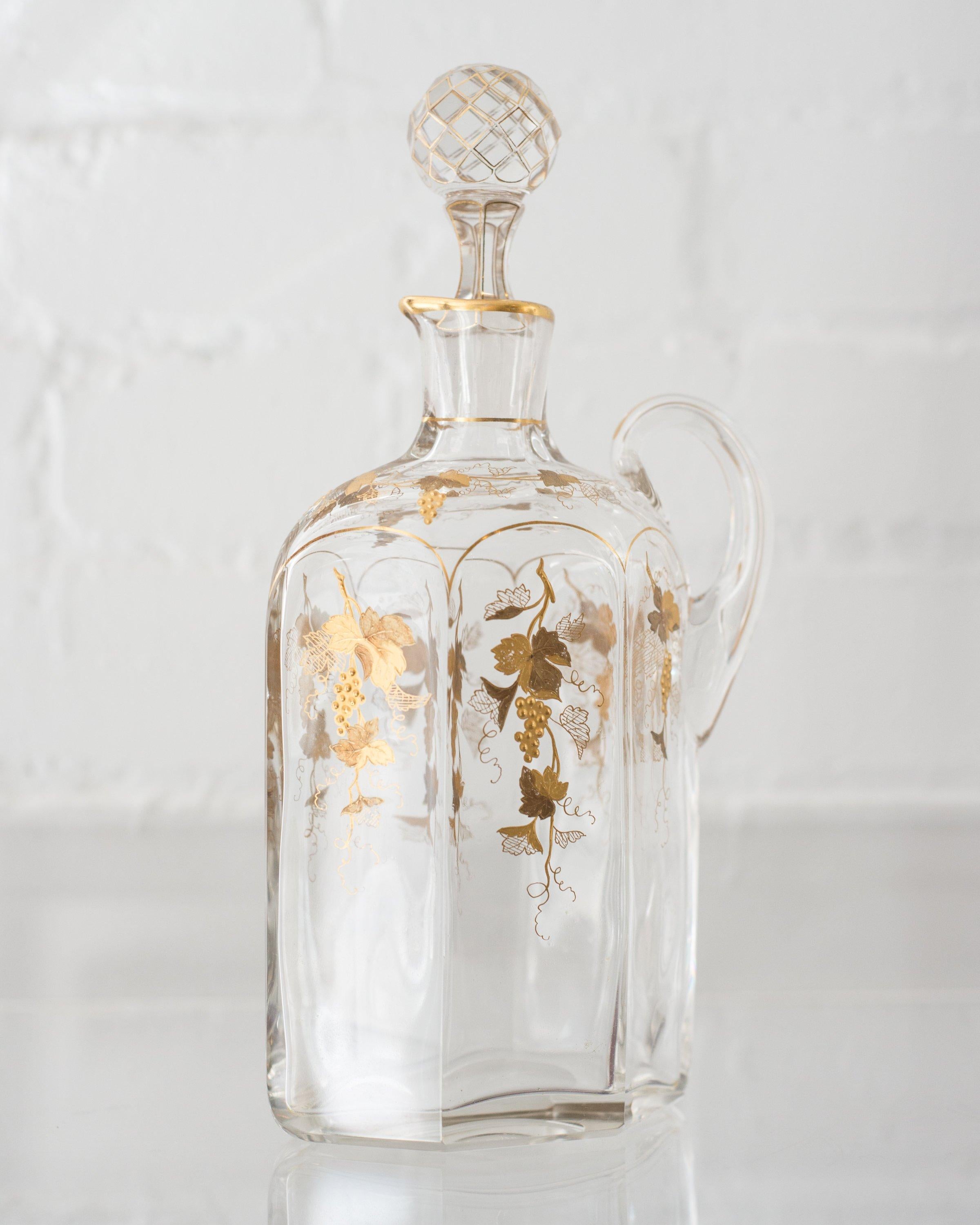 This antique Bohemian glass decanter with gold gilt grapes was originally used for wine. Gilding in very good condition for age. Today it can be used to serve a variety of drinks and is ideal for housing salad dressing.