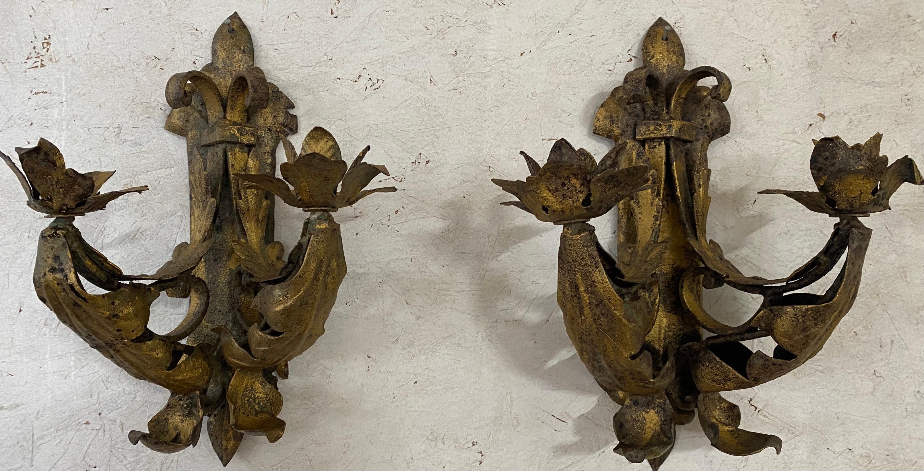 La paire d'appliques en fer artisanale de style baroque ancien est décorée de diverses formes de feuilles et est fixée par des supports, chacun avec un trou en haut pour attacher une vis ou un clou à un mur. Chaque applique peut contenir deux