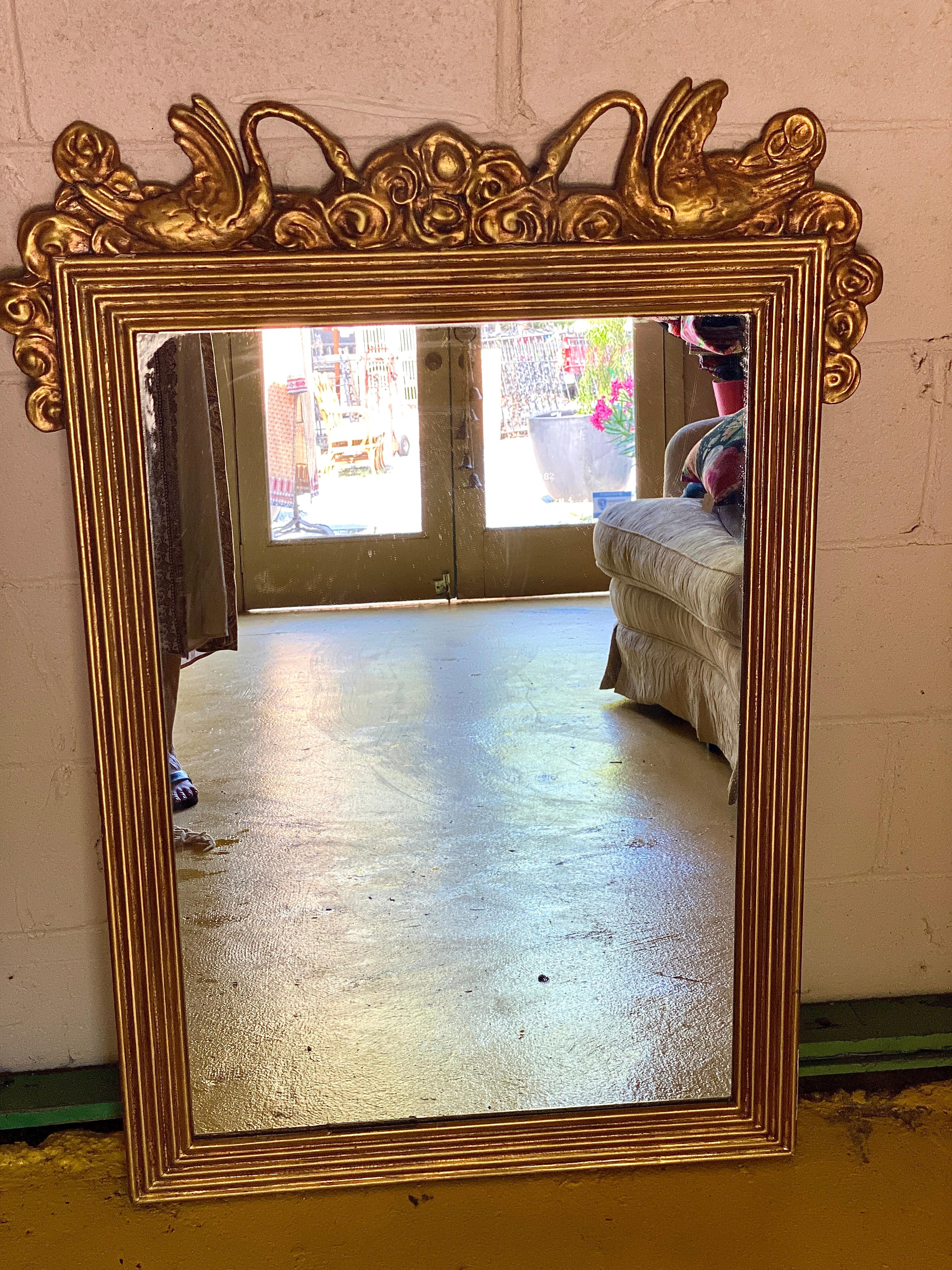 Antique gold leaf gilded swan mirror. This is a beautiful mirror with delicate detail of swans. This mirror could be used as an accent piece on top of your mantle or as a decorative object in any room.