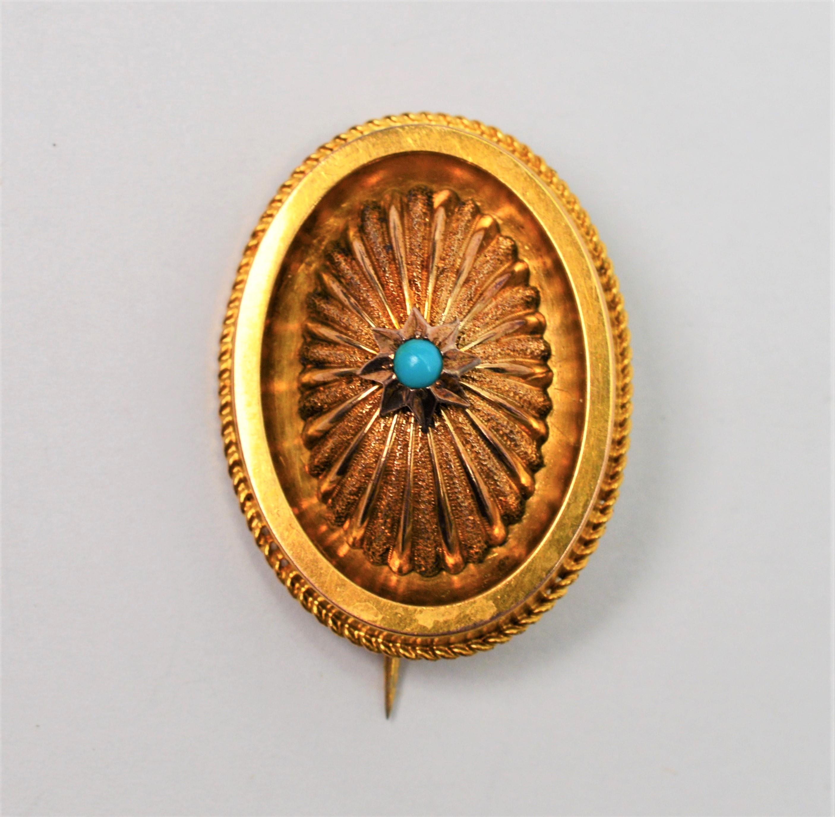 A classic accent for a scarf or pashmina. In a petite oval shape measuring 1-1/4 x 7/8 inches, the fourteen karat 14K yellow gold brooch has well defined dimensional details with one quarter inch depth rising to the medallion's pinnacle center