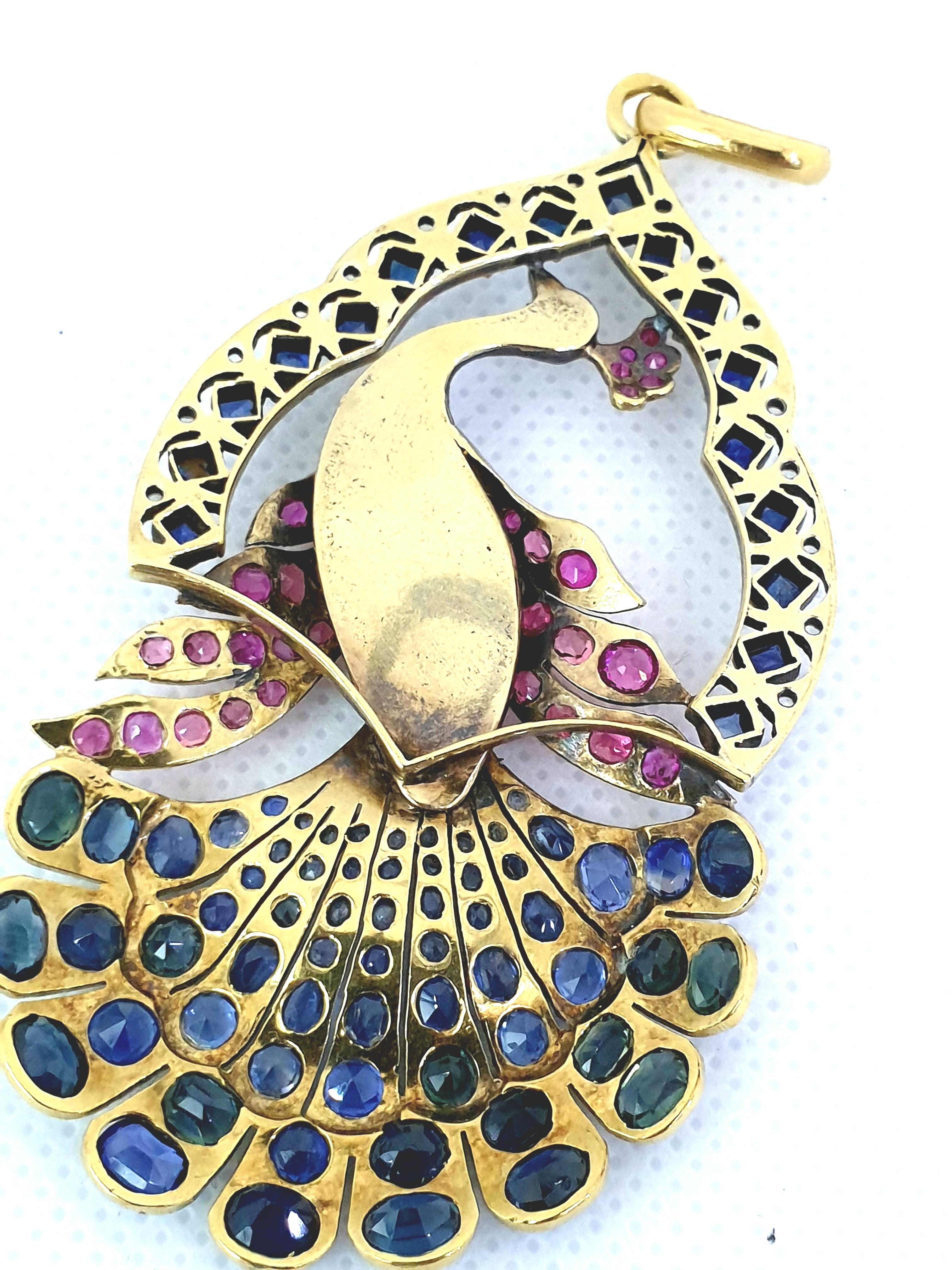 Antique peacock pendant Victorian time era. The peacock is set with variety gemstones:pink and blue sapphires and diamonds. Most of the stones are natural but few got replaced with synthetic stones. The body of the peacock is pave set with rose cut