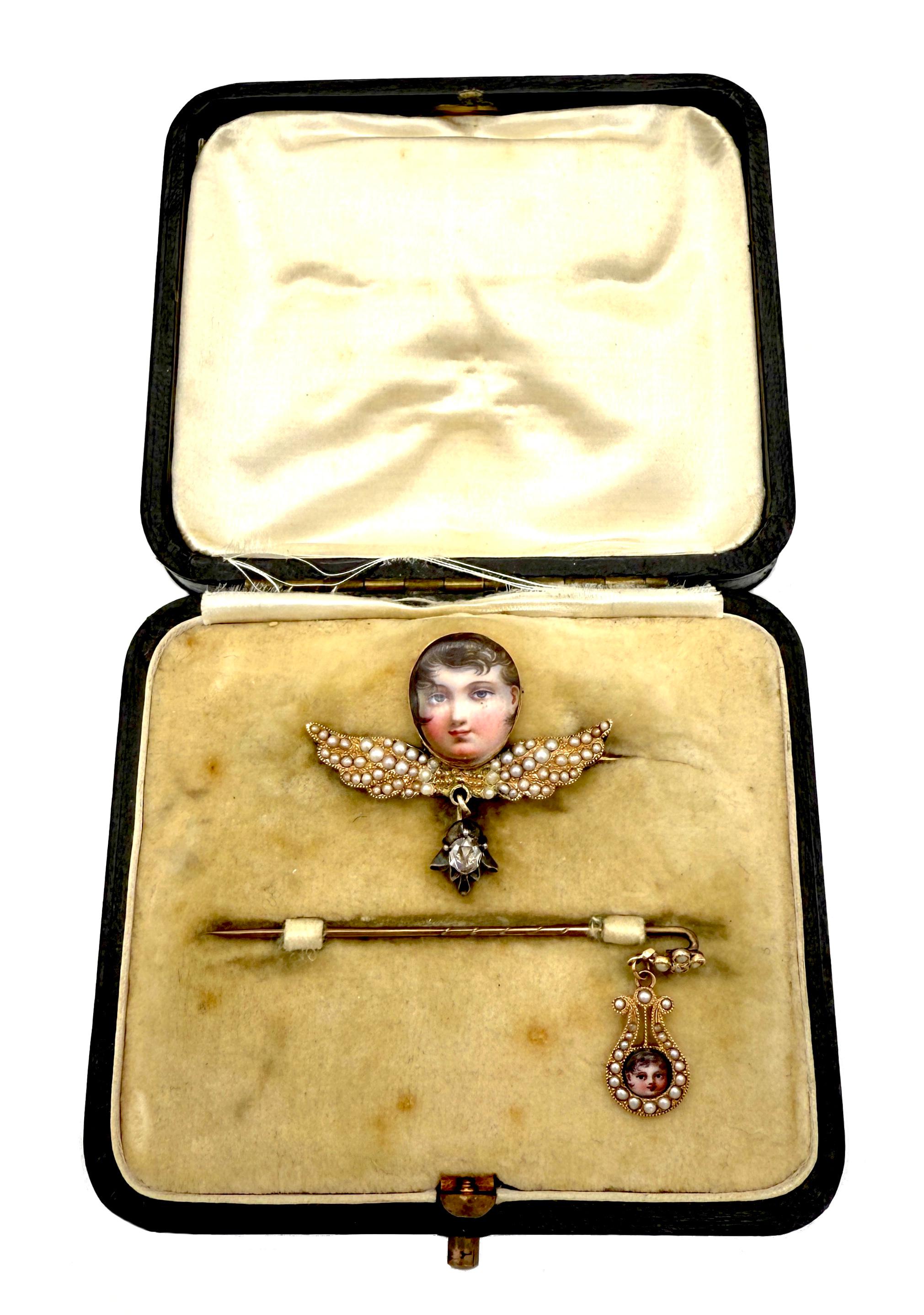 Questo set di delicate miniature in smalto è stato creato all'inizio del XIX secolo. I piccoli ritratti erano  dipinto a smalto. Il volto del bambino più grande è montato in oro con un medaglione sul retro. La spilla di metallo contiene una piccola