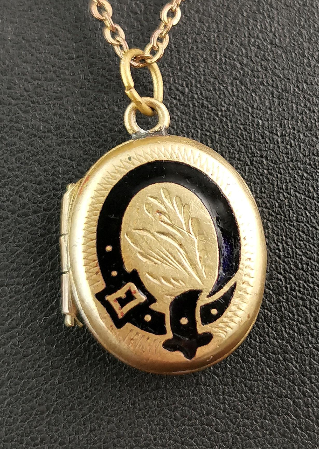 A sweet antique Edwardian era gold plated metal mourning locket.

This locket is a chunky little locket, gold plated with a black enamel garter belt to the front.

Internally it has blue paper and room for two photographs.

The locket comes on a