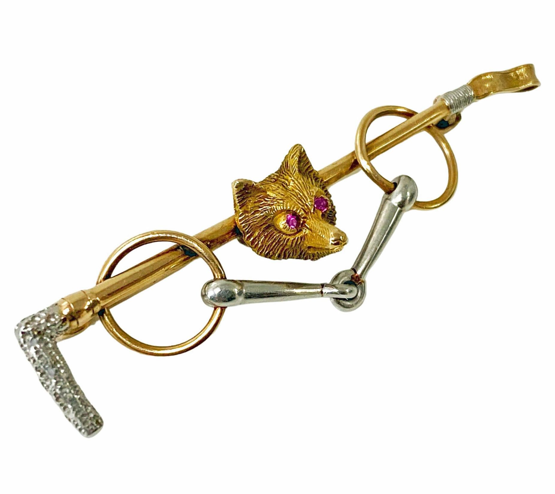 Antique Gold Platinum Ruby Fox Brooch complete with stirrups and riding crop circa 1900. The fox head surmounted on a platinum and gold riding crop with stirrups attached, eyes set with small round facetted natural Medium Strong Red Rubies,