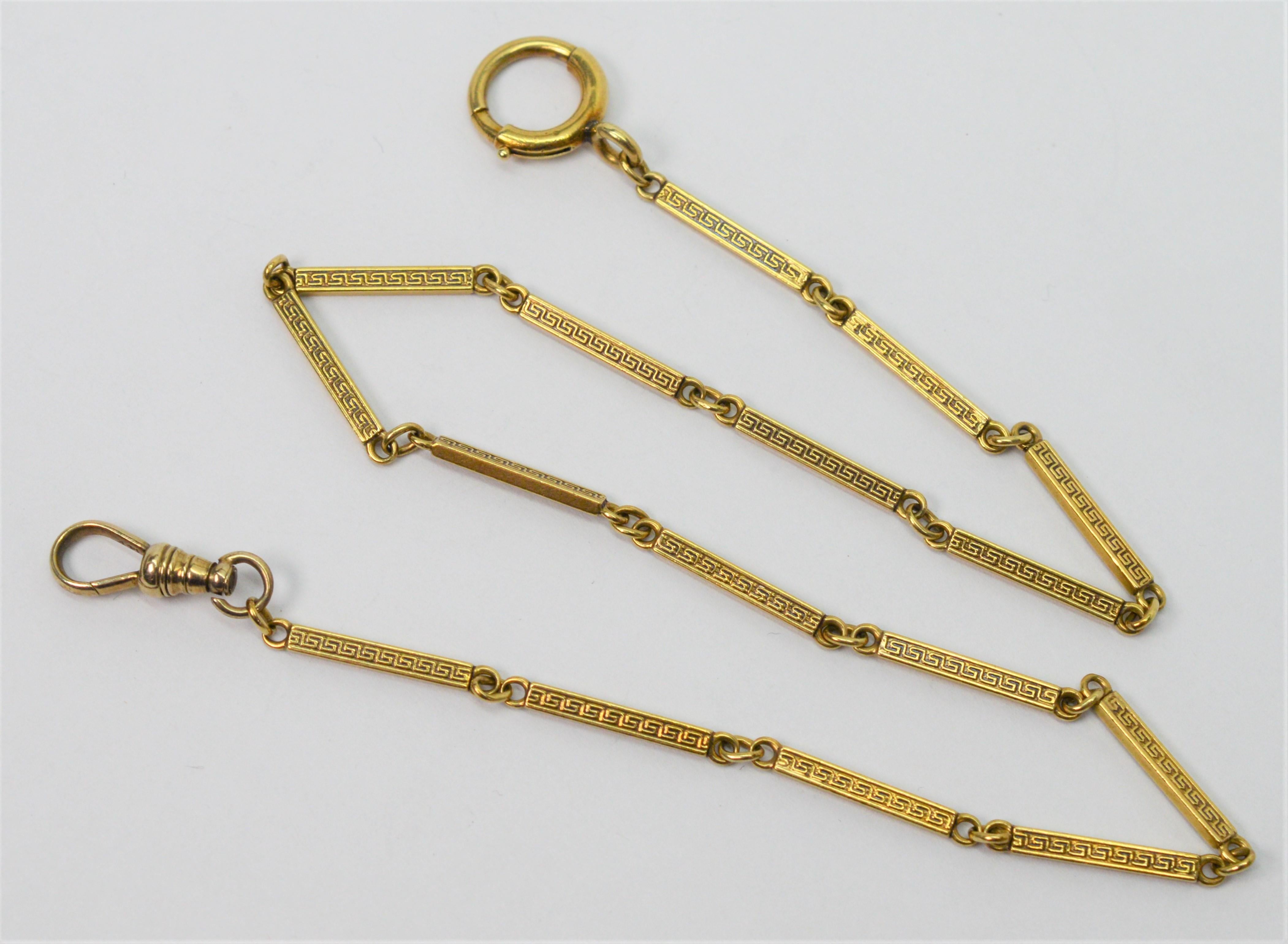 Made in fourteen karat 14K yellow gold with soft antique toning, this pocket watch chain is nicely appointed with an attractive Greek border design that appears
 on the 3/4 inch long links and creates its 15.5 inch length. The pocket watch chain is