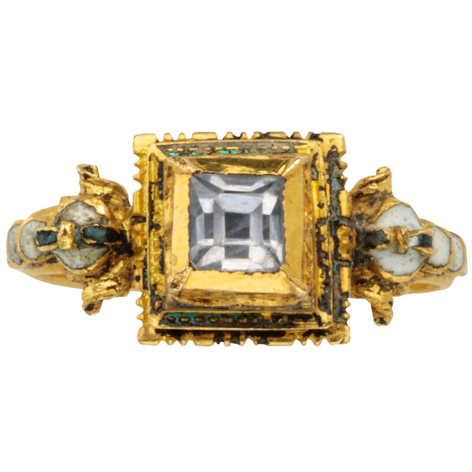 RENAISSANCEREHERING
Westeuropa, ca. 1600-1620
Gold, Bergkristall und weiße Emaille
Gewicht 5.9 gr., US Größe 5.25, UK Größe K 

Dieser goldene Reif mit D-förmigem Querschnitt verbreitert sich zu Schultern, die in kunstvollen Schnecken enden. Diese