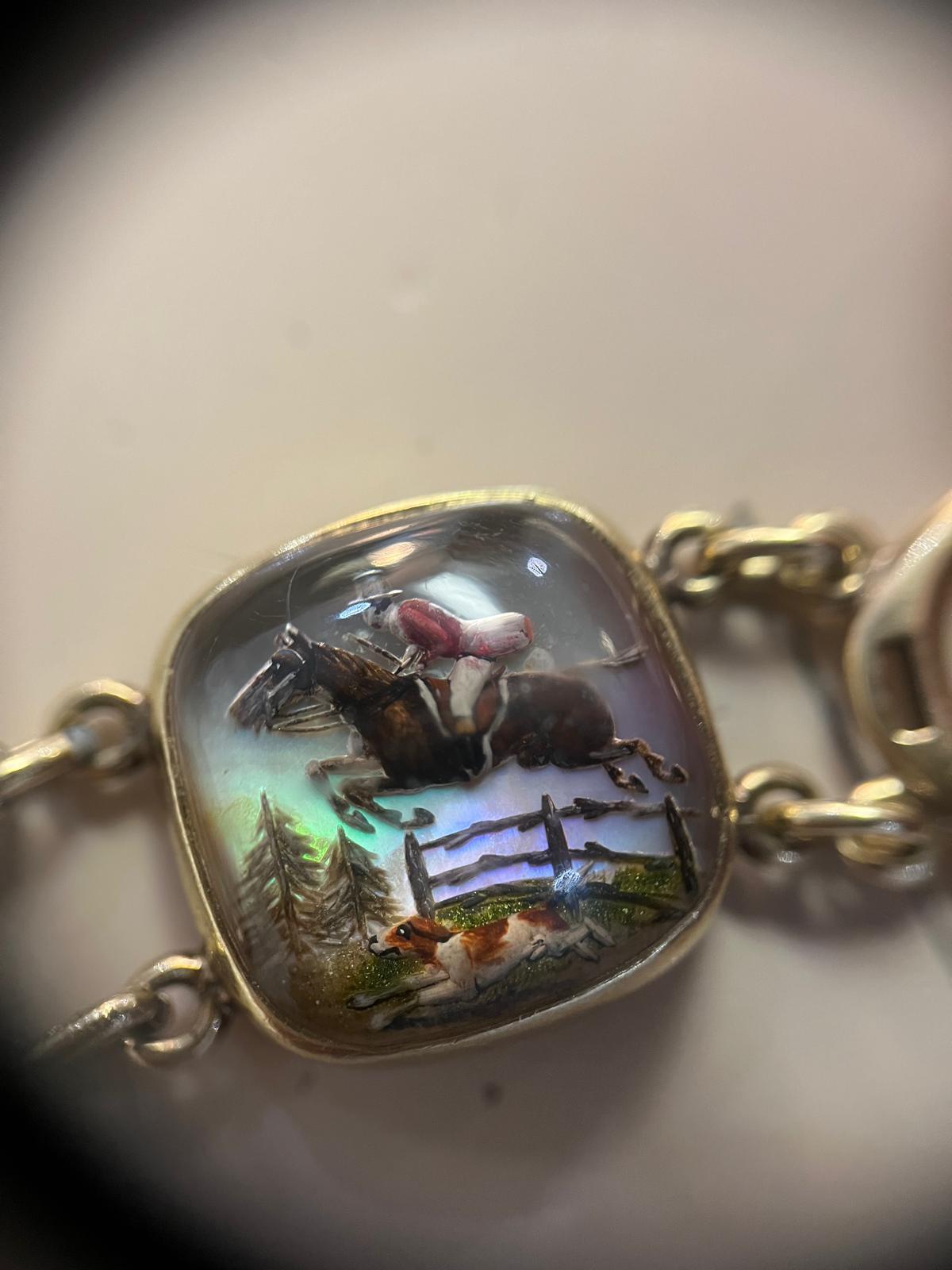 This is a breathtakingly beautiful, and today highly rare, reverse painted Essex crystal bracelet. One link depicts a compassionately rendered portrait of a hunting beagle in profile, the second depicts an enthusiastic hound running whilst its owner