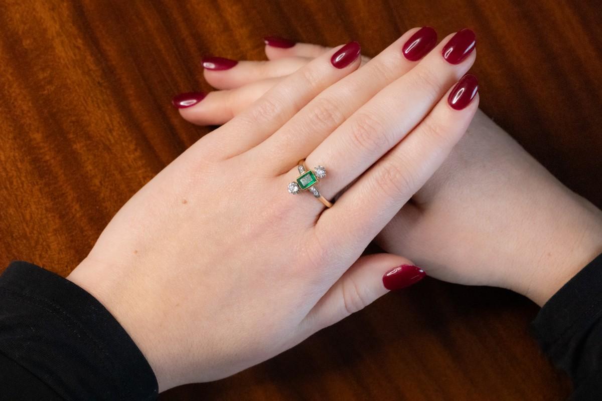 Beautiful geometric ring in the Art Deco style, made of 18-karat gold and platinum elements.

Centrally decorated with an emerald in a step cut and symmetrically set diamonds in an old brilliant cut with a total weight of approx. 0.40ct

Origin: