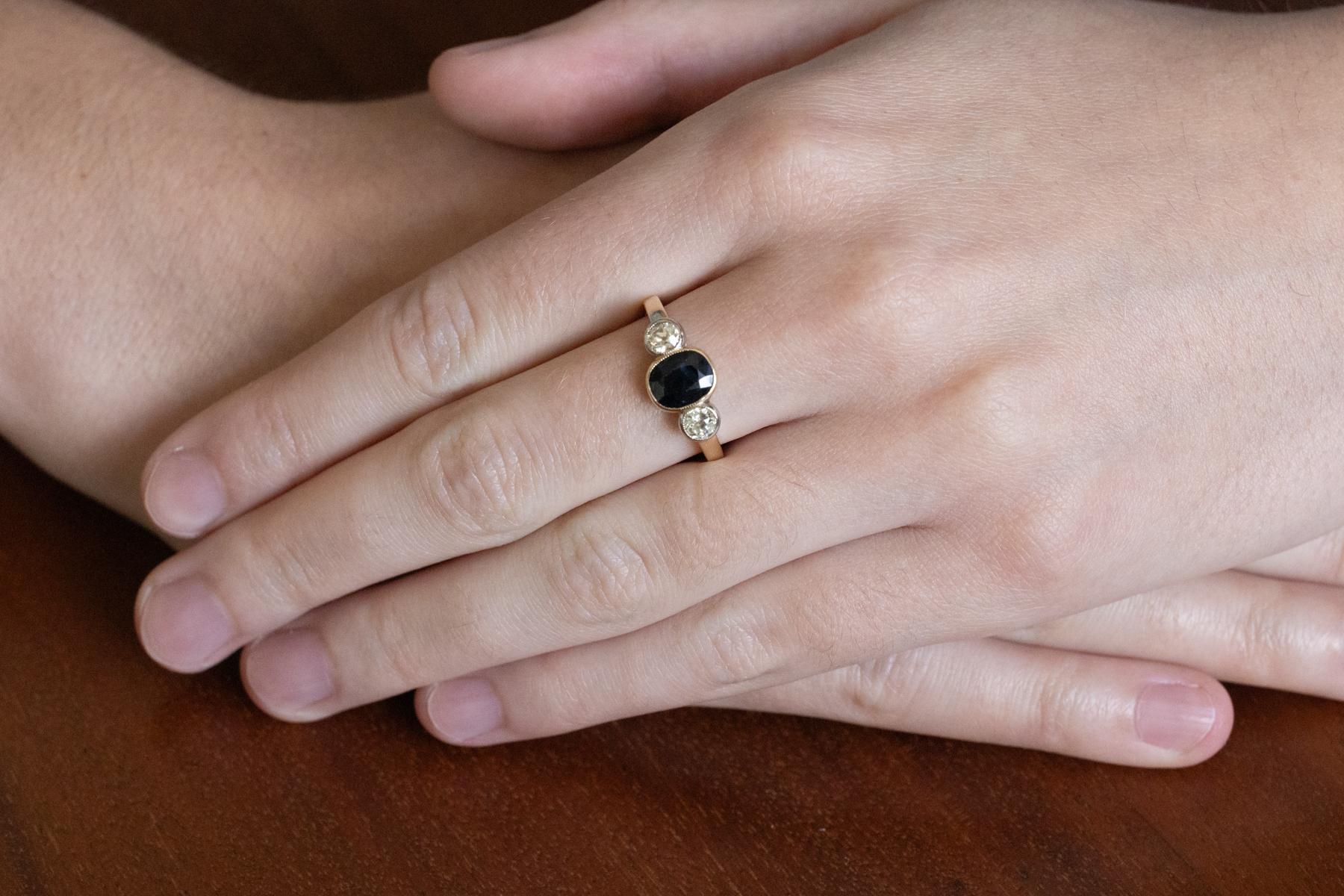 A beautiful vintage ring crafted from 14-karat yellow and white gold (0.585 fineness).

Adorned with a central oval, faceted sapphire, beautiful garnet blue, weighing approximately 1.60 ct, surrounded by two 