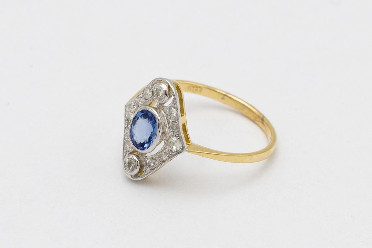 The antique gold ring comes from mid-20th century Great Britain.

Made of yellow 18-carat gold (0.750 fineness).

Set with 12 brilliant-cut diamonds, total weight 0.20ct (color G-H, purity SI1-I1) and an oval light blue sapphire weighing