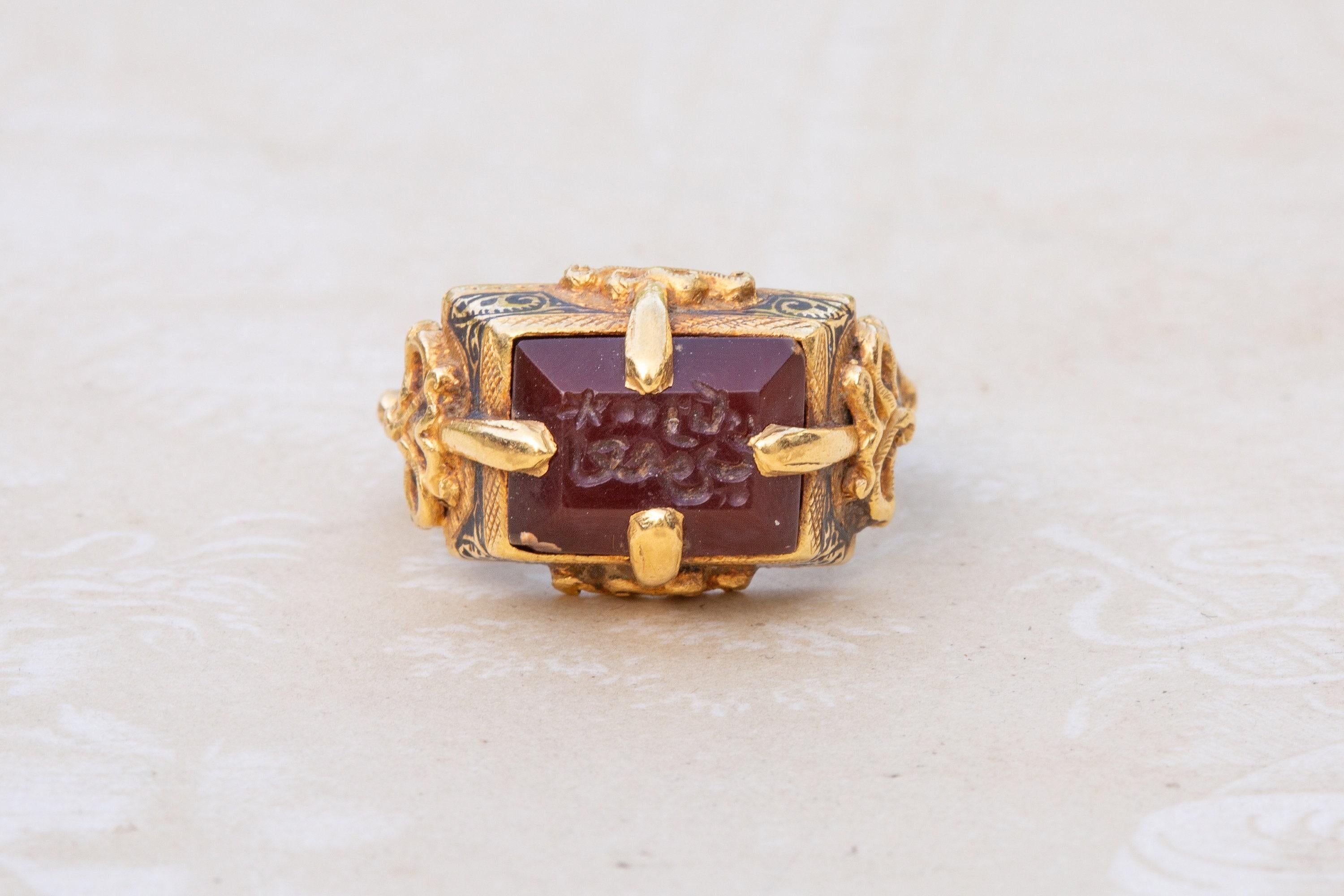 This incredible, rare gold ring dates from the 12th century Seljuk dynasty. The carnelian intaglio is set within a typical Seljuk tapered rectangular bezel with a four-pronged gold setting soldered to the outside of the bezel. Applied and pierced
