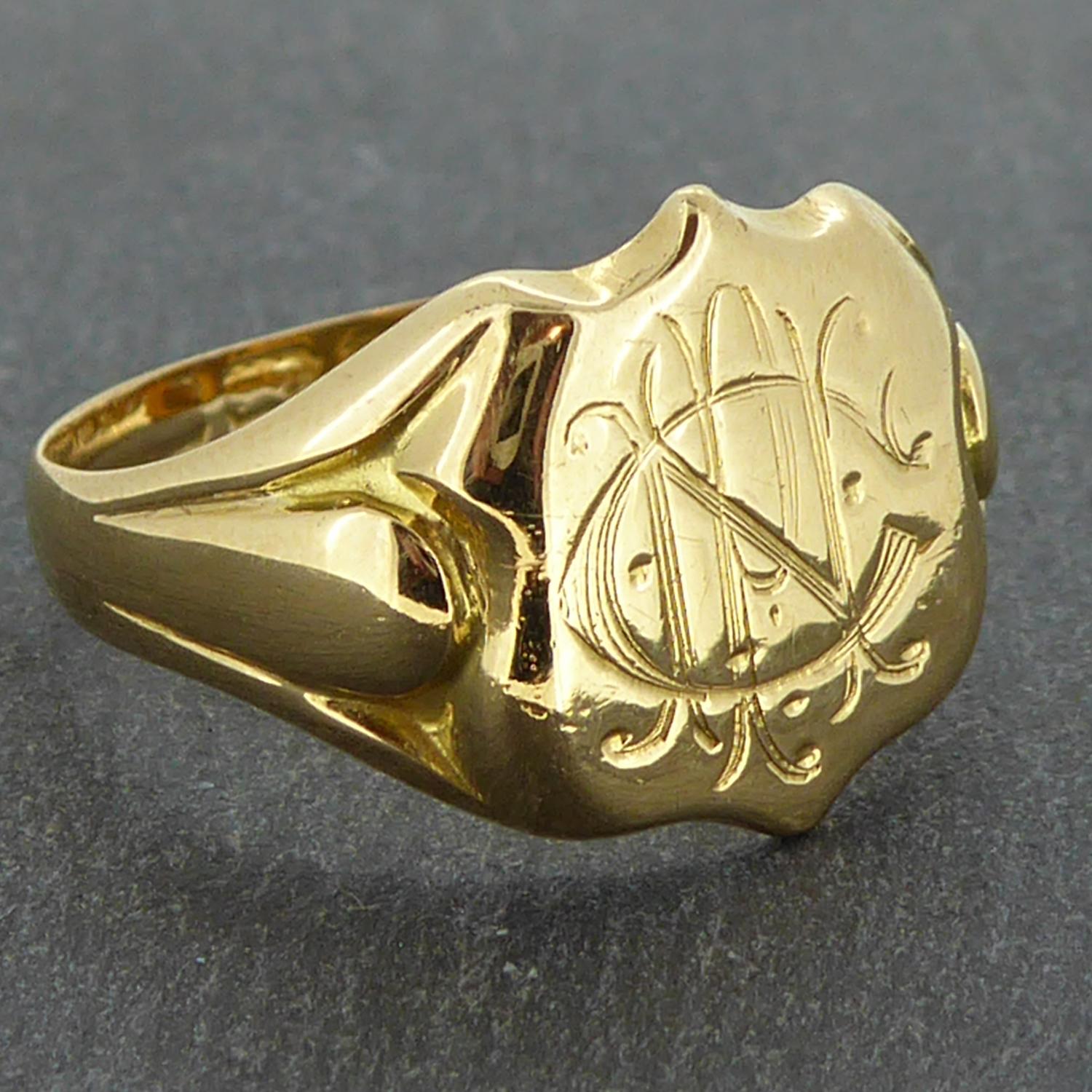 A magnificent old gold signet ring for men enhanced by the gracefully carved initial of C,N, and P in a flourished script.  The head of the ring is a shield shape measuring approx. 11.00mm x 13.0mm (maximum dimensions) to flared shoulders with a