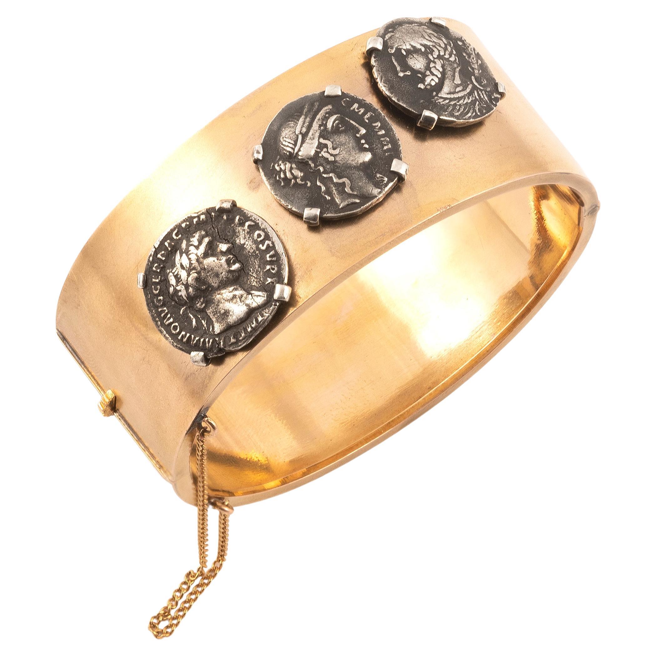 18k gold  silver roman coin motif bangle bracelet,
gross weight approximately: 31,36g.; diameter: 2 3/8in. 
Denarius  Roman Republican  Quinctius 112 A.C.
Denarius republican C. Memmia 56 A.C.
ROME-Denarius-Traianus-98-117 A.C.