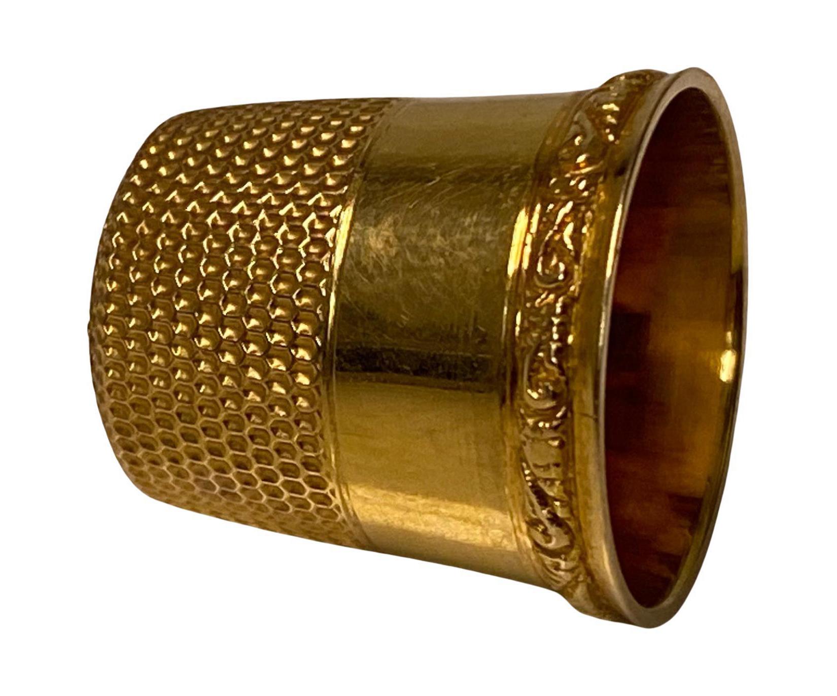 Antiker goldener Fingerhut C.1900. Durchmesser 1.8 cm. Höhe: 1.9 cm. Gewicht: 4.0 Gramm. Markiert 10K mit einem Anker auf der Innenseite. Geripptes Tupfenmuster um den unteren Teil, schlichter oberer Teil mit Laubrand. Zustand: Gut. 
