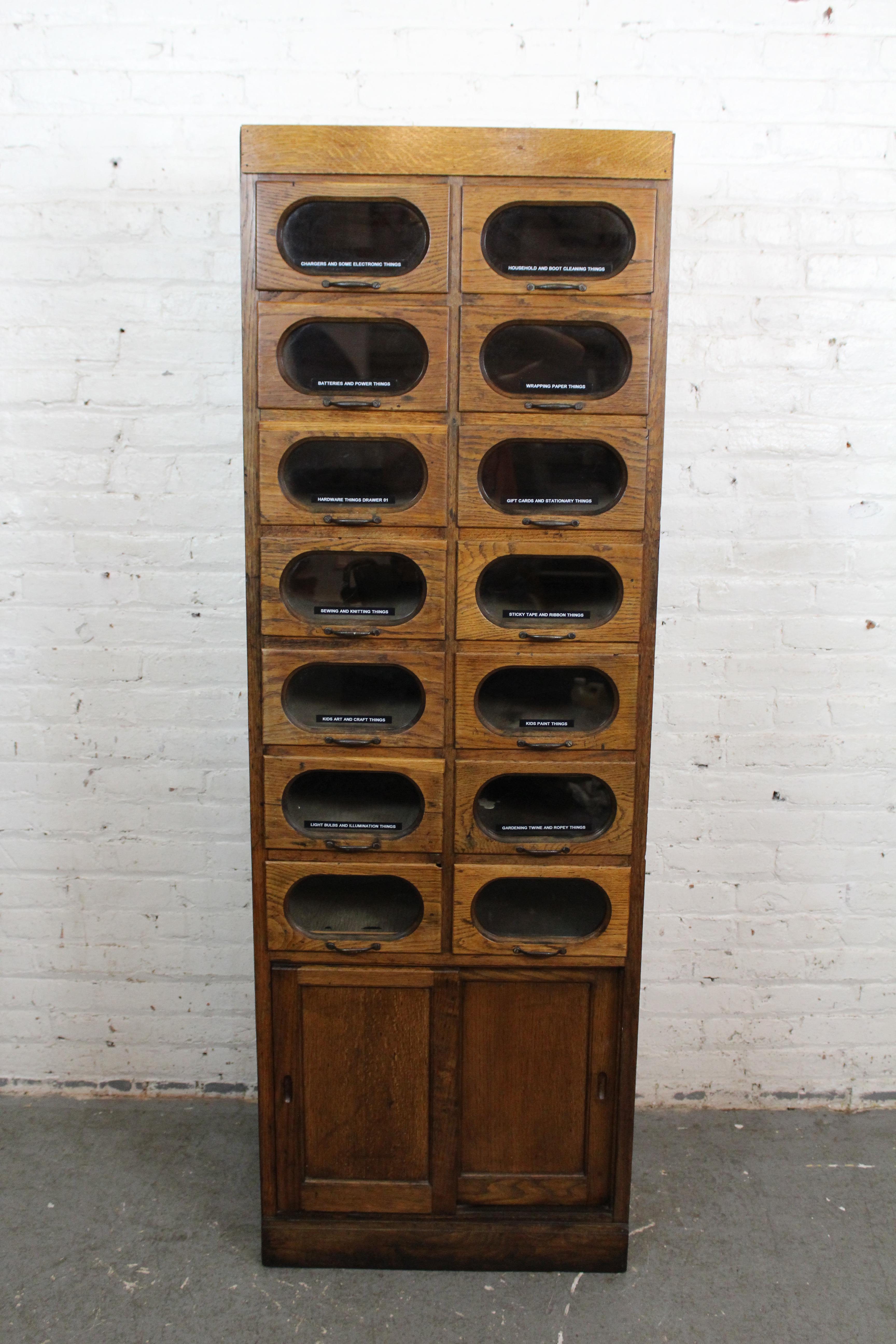 Bring home antique furniture worth tipping your cap for! Don't miss out on this truly one-of-a-kind haberdashery cabinet built by Dudley & Company of England. This beautiful artifact of the early 20th century proudly features the gorgeous waves of